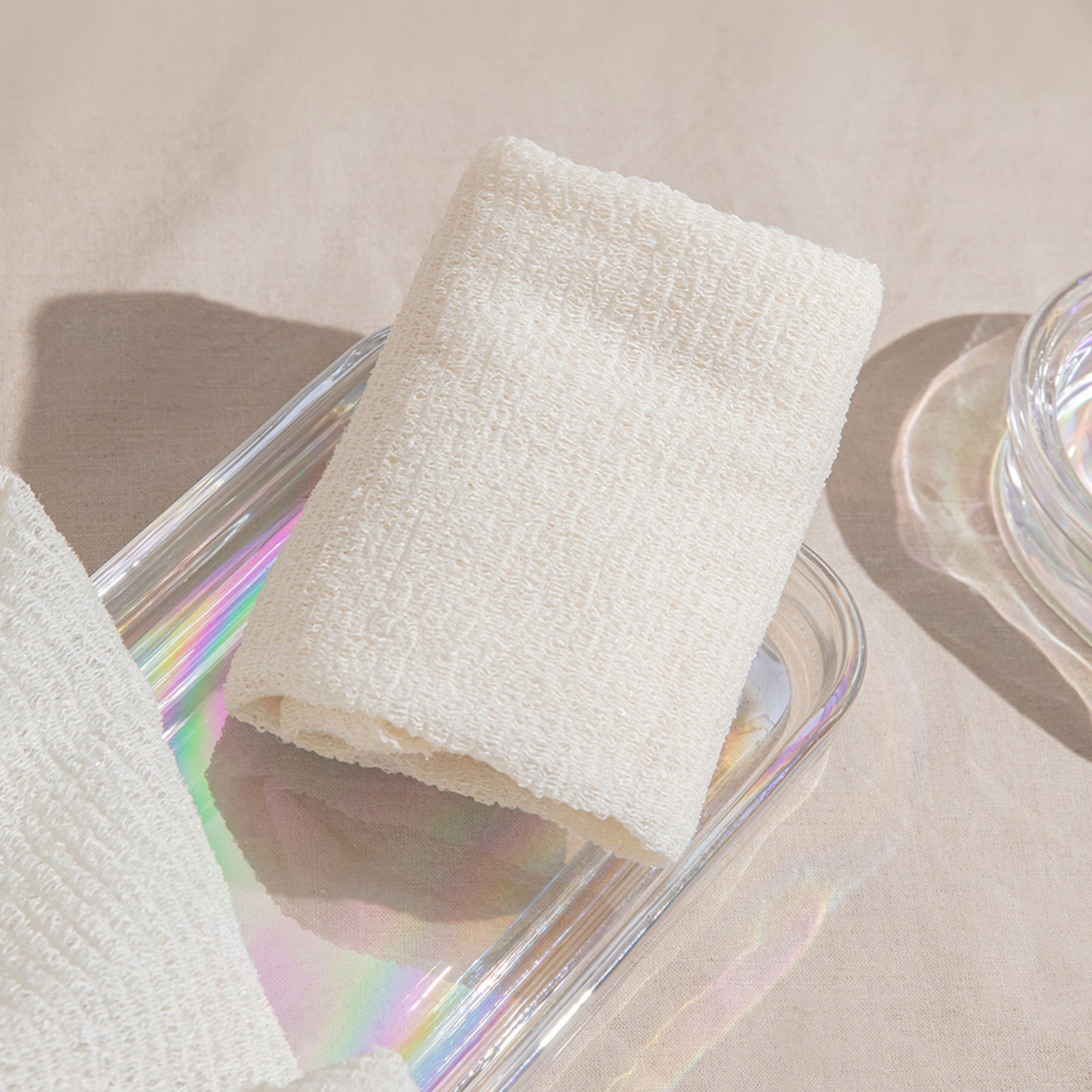 White textured roll of paper towel on a clear glass surface with a neutral background