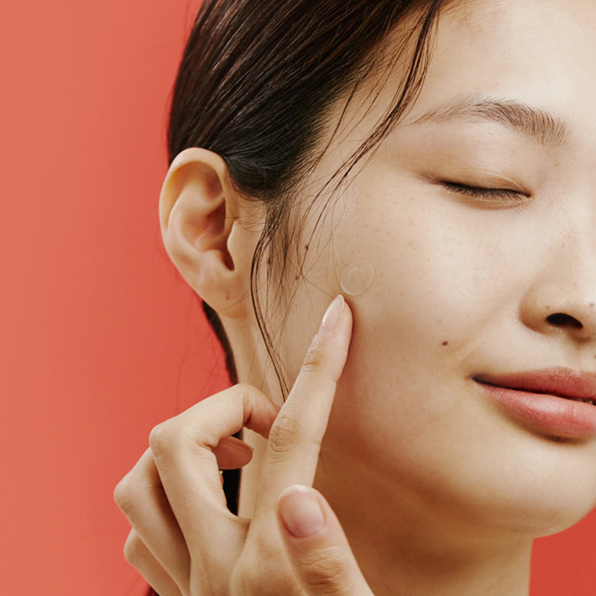 Woman touching her face with a red background