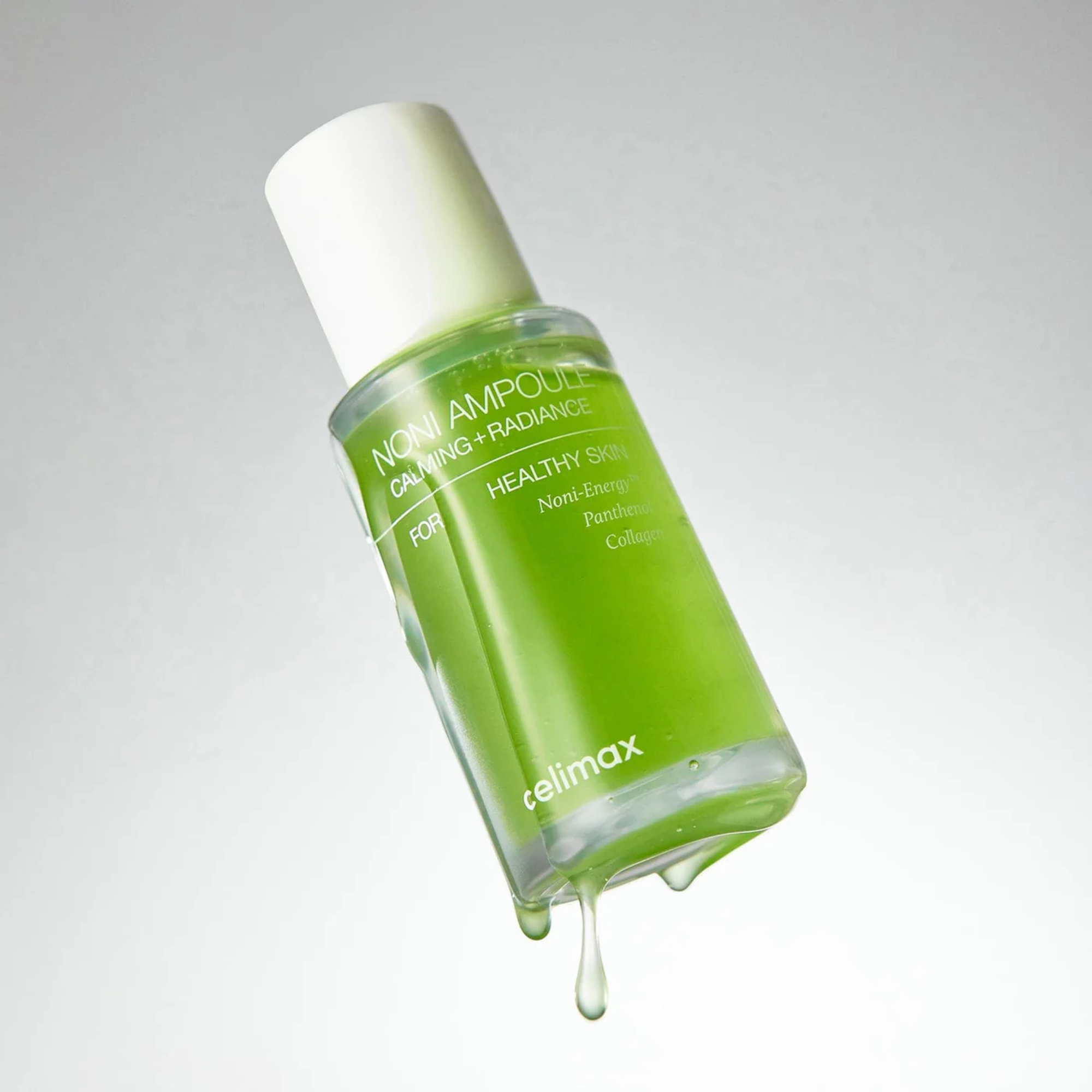 Green skincare bottle with white cap on a gray background
