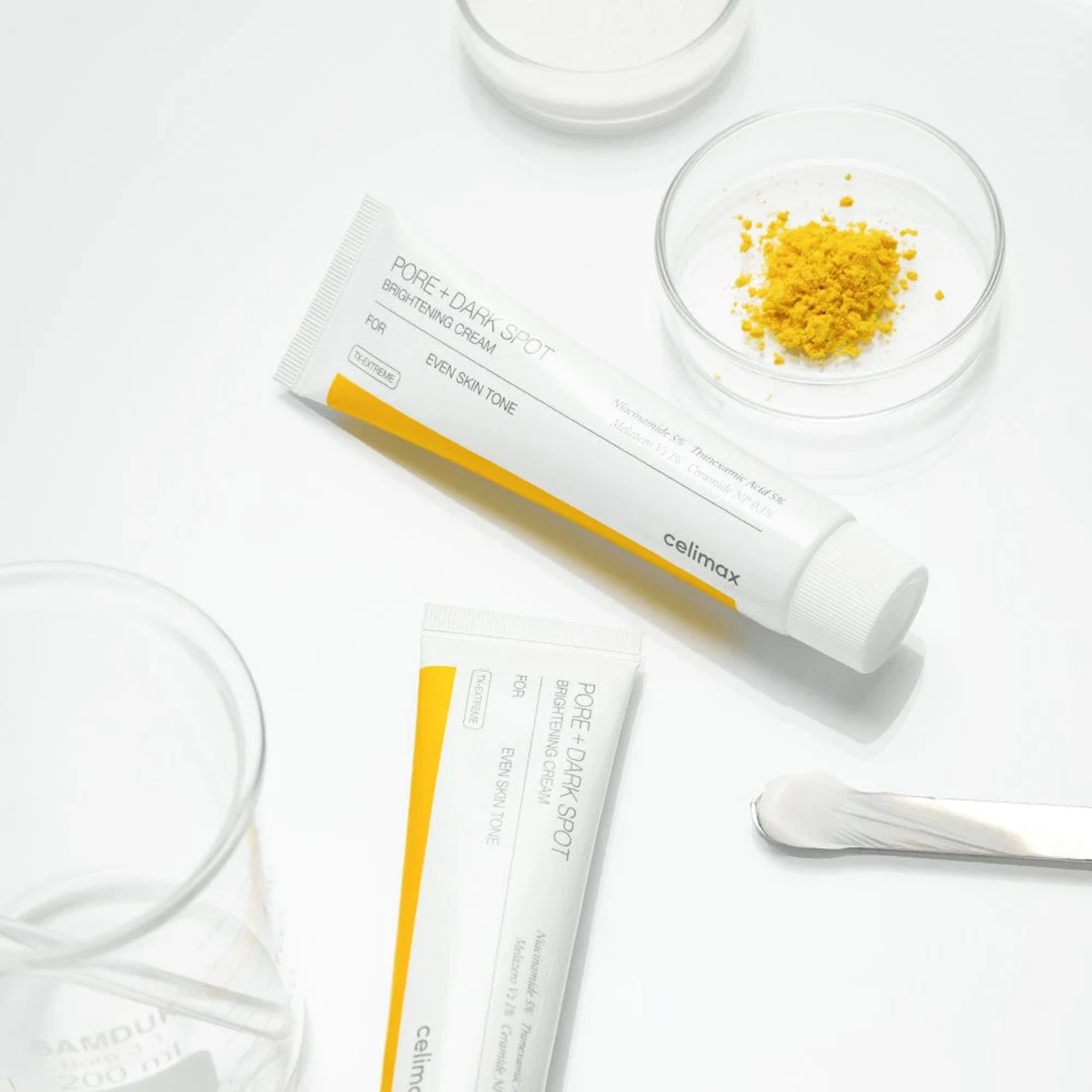 Two tubes of Cellmz skincare product on a white background with small bowls containing yellow powder and clear liquid.
