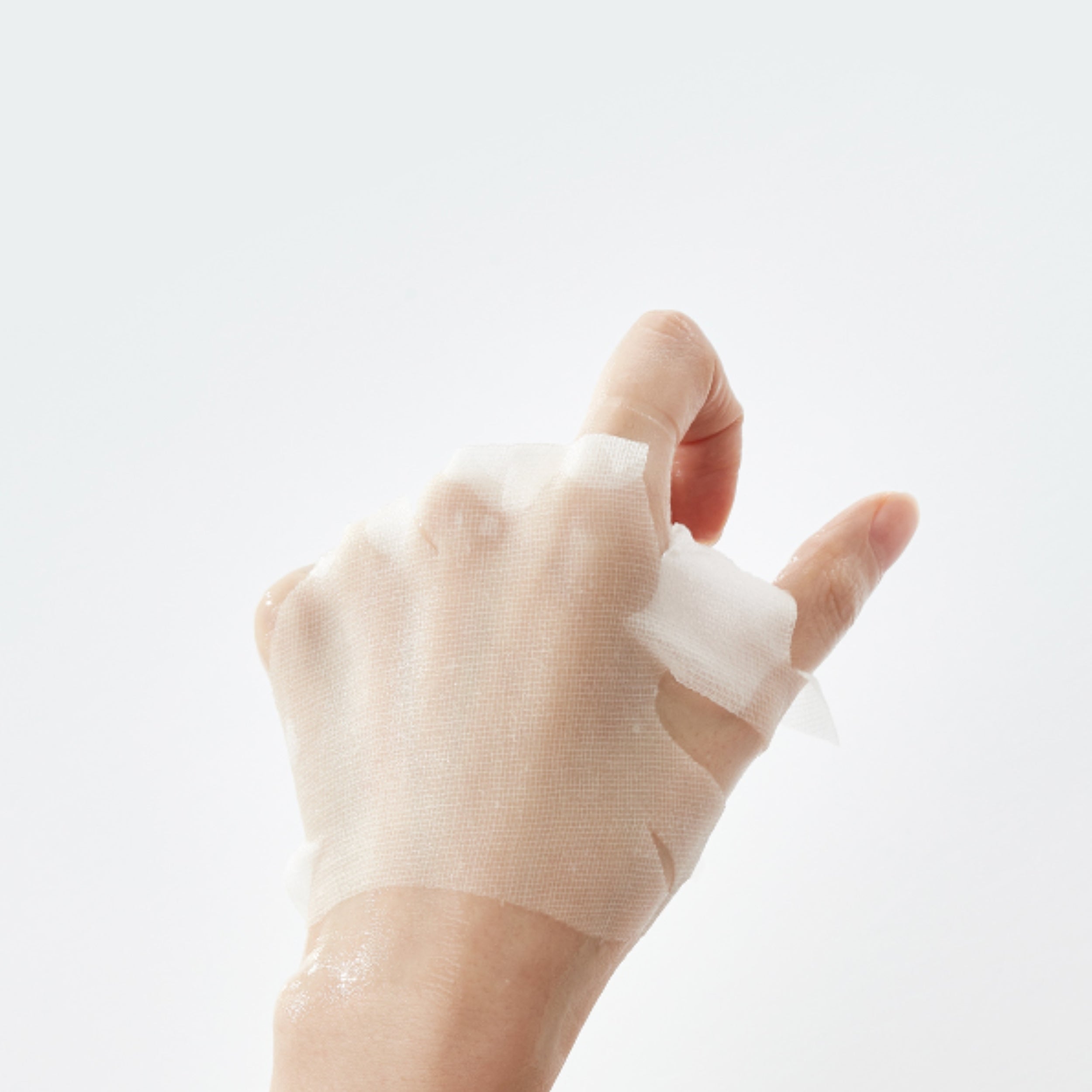 Hand applying cream to a finger on a white background