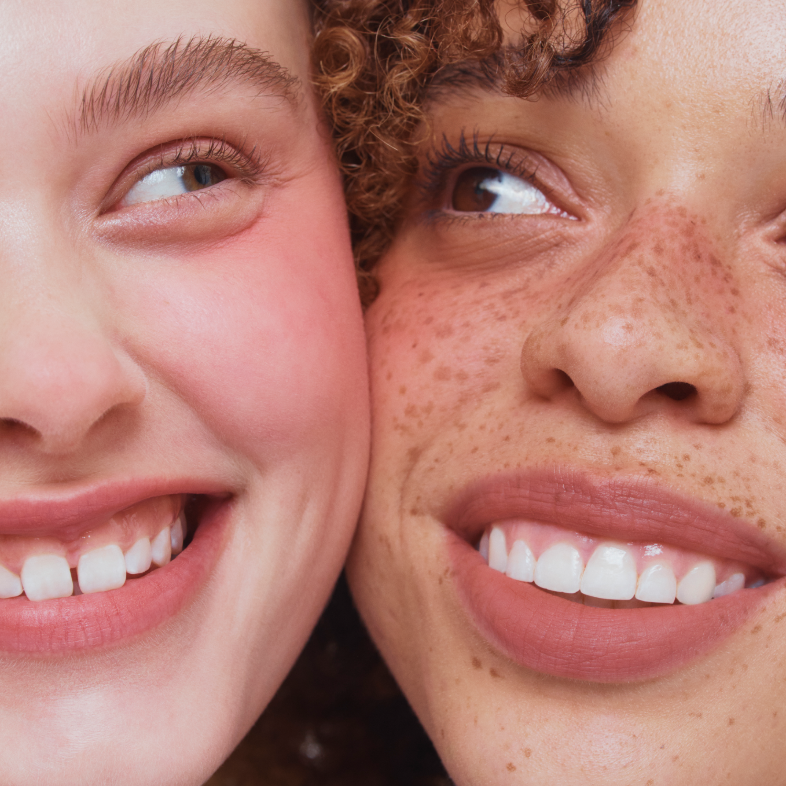 Close-up of two people smiling with a focus on their teeth.