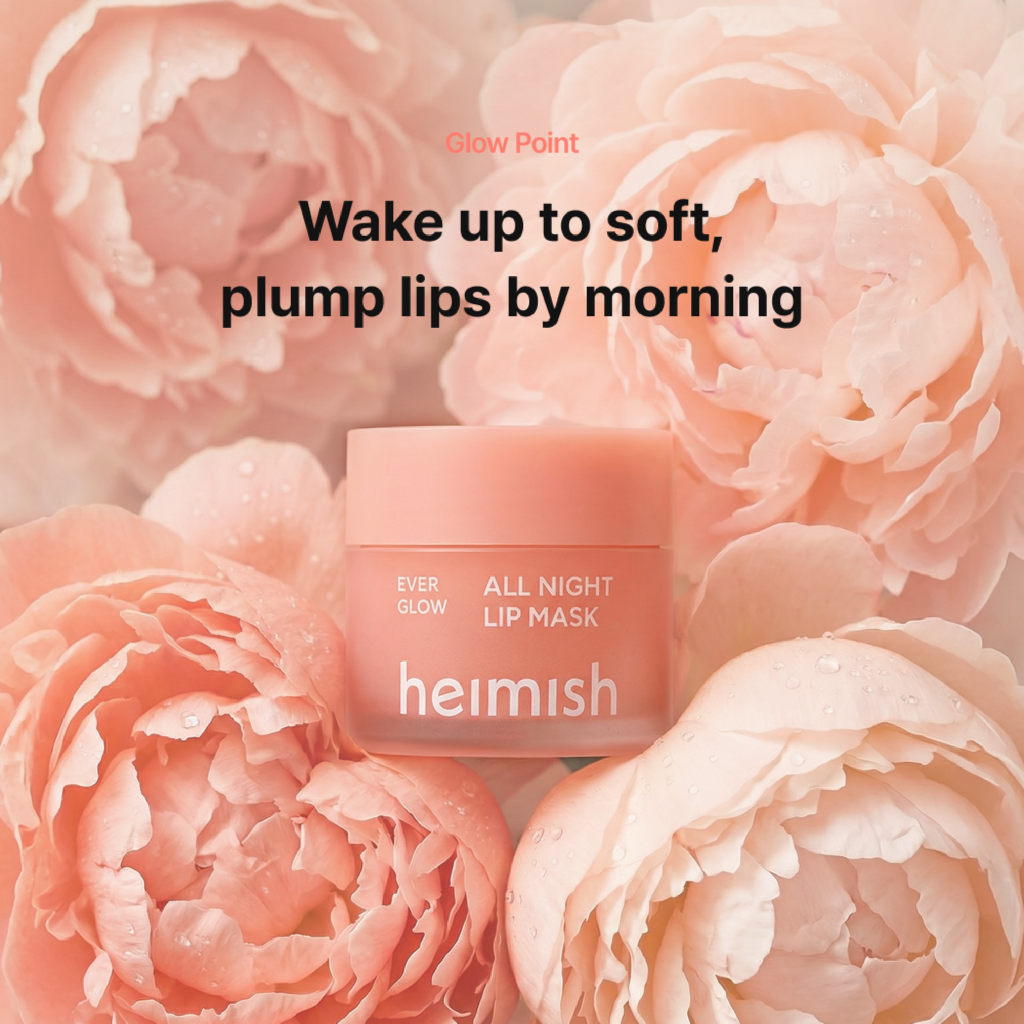A jar of Heimish Ever Glow All Night Lip Mask centered over a soft pink floral background with large peach blossoms. Text above reads, 'Wake up to soft, plump lips by morning.