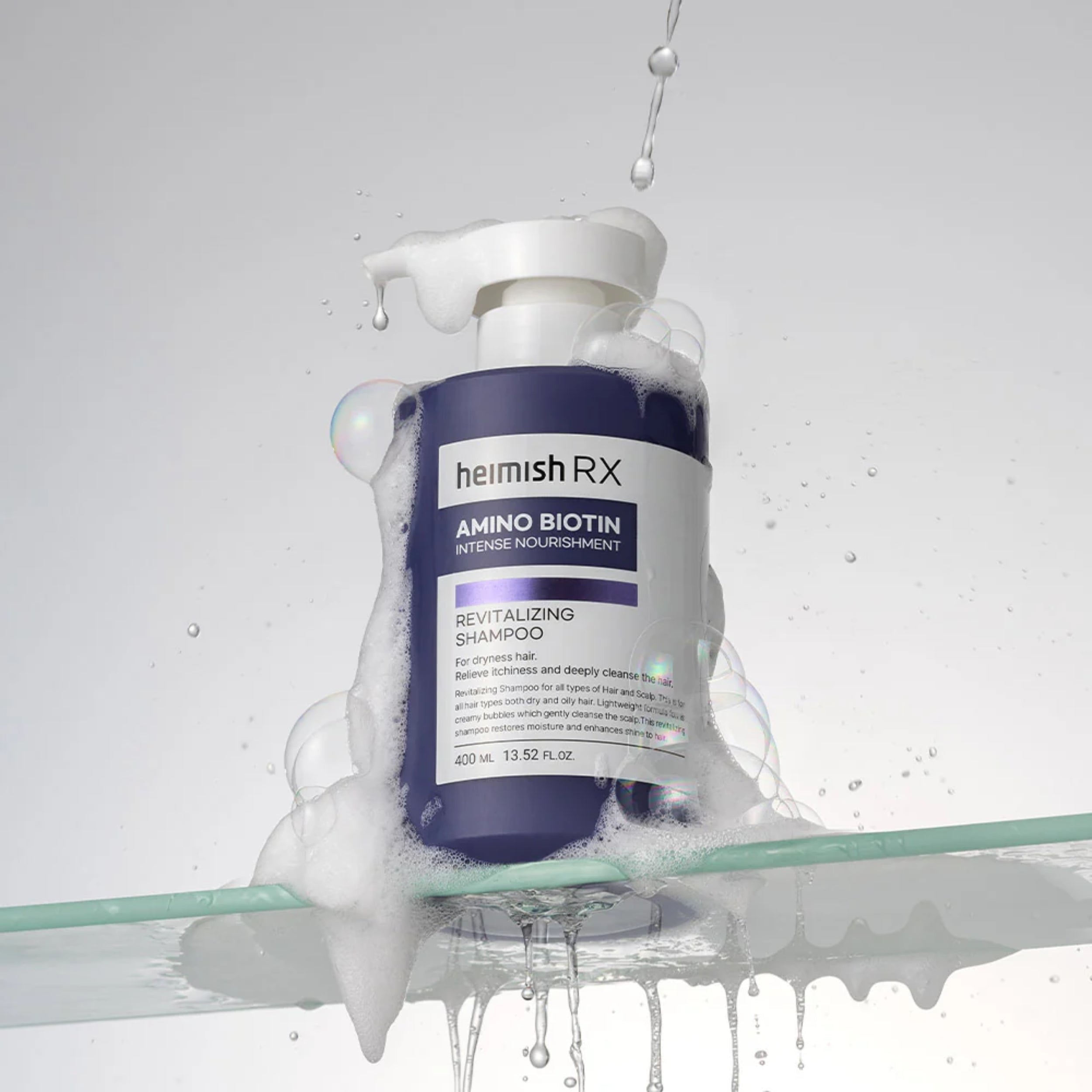 Himish RX Amino Biotin shampoo bottle with water droplets on a gray background