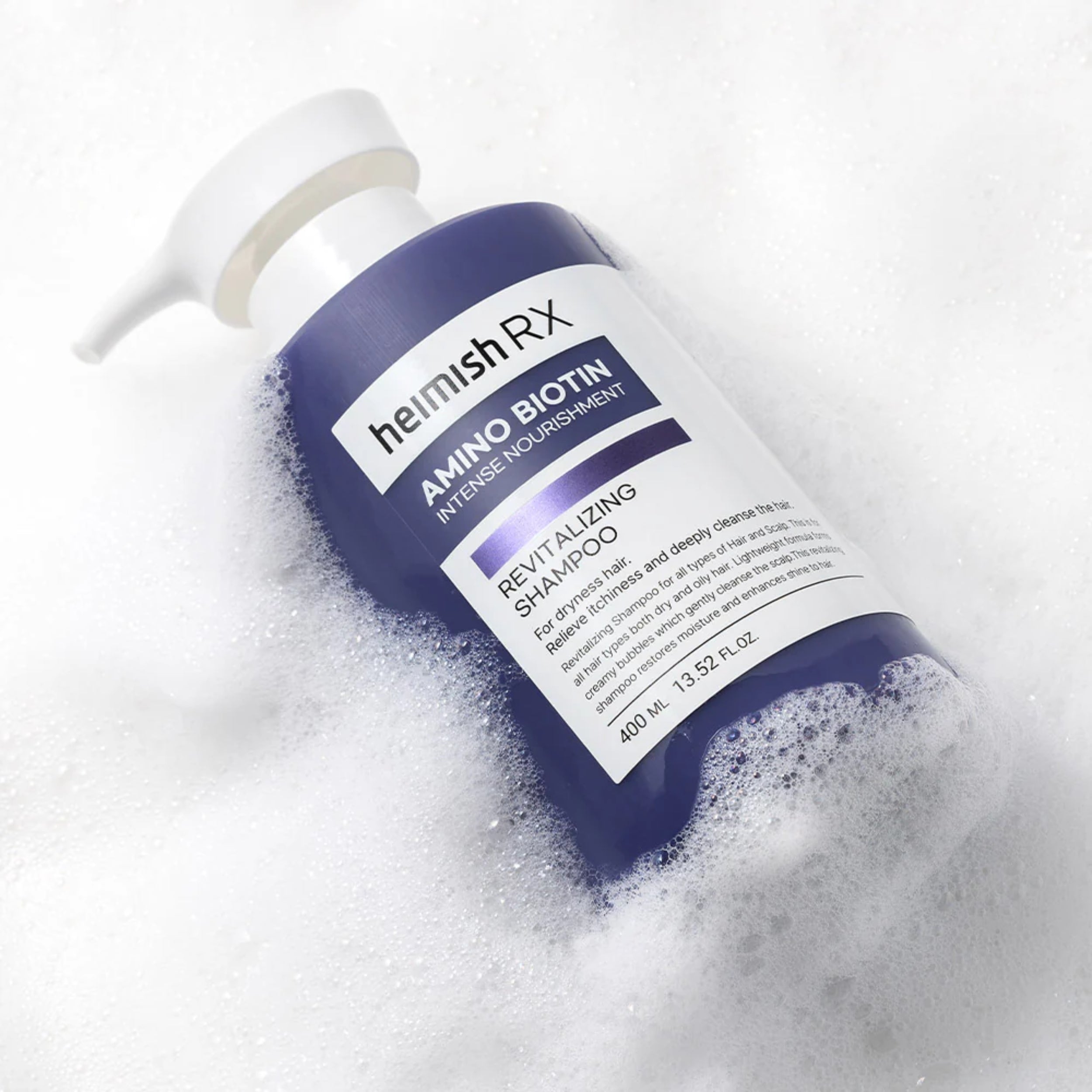 Bottle of hemish Rx Amino Biotin shampoo surrounded by bubbles on a white background