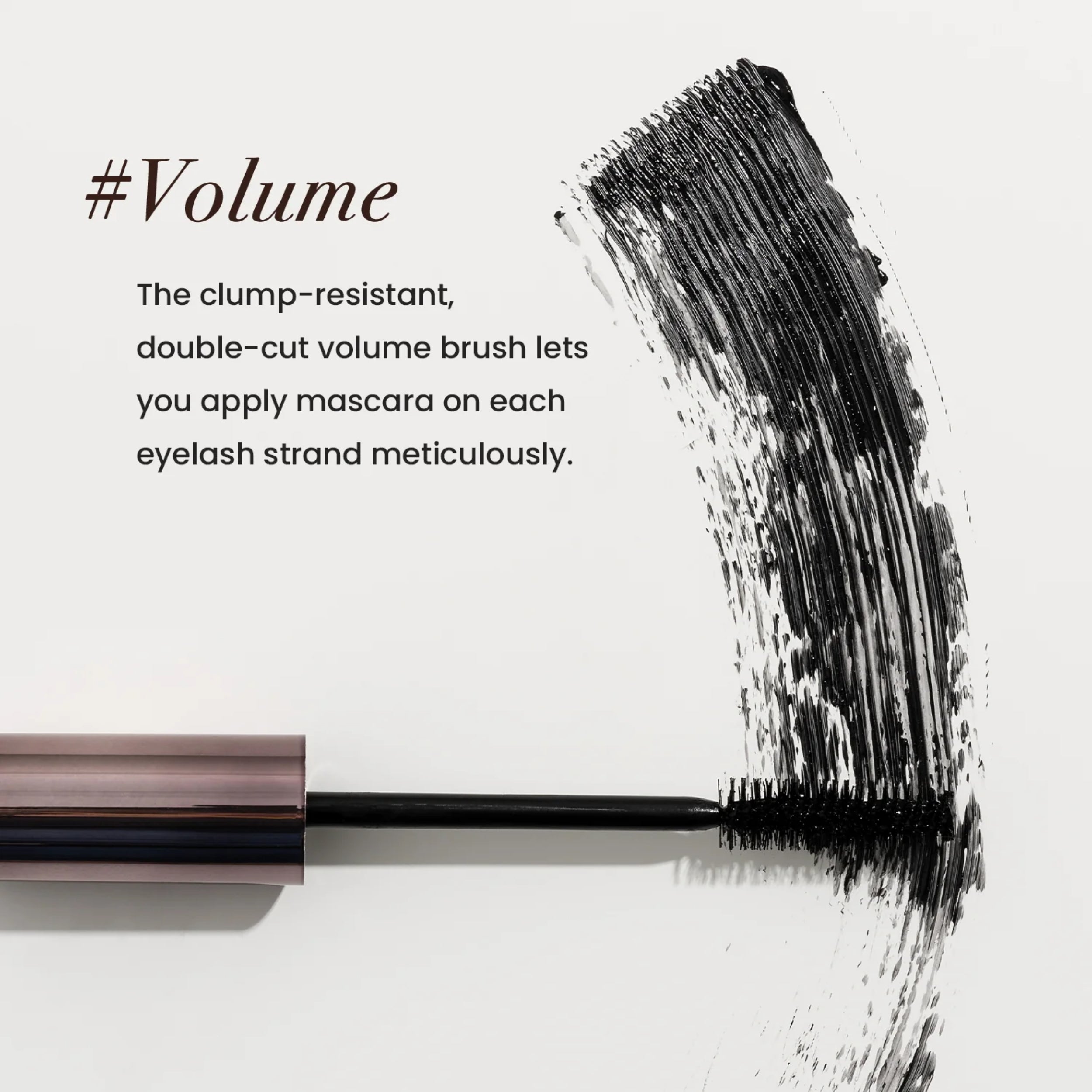 Mascara wand with a brush stroke on a white background, featuring text about clump-resistant double-cut volume brush.