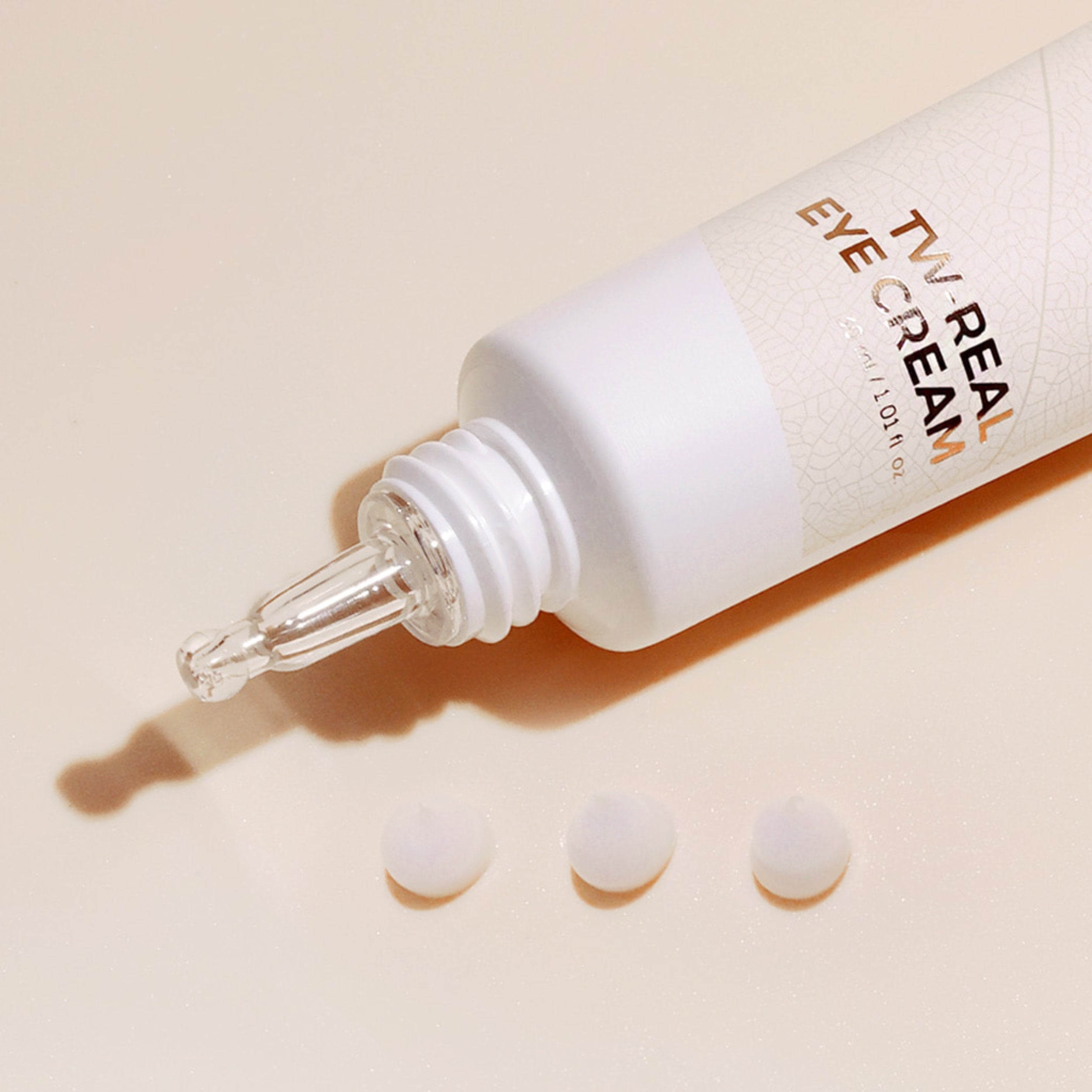 TV Real eye cream bottle with dropper on a beige background