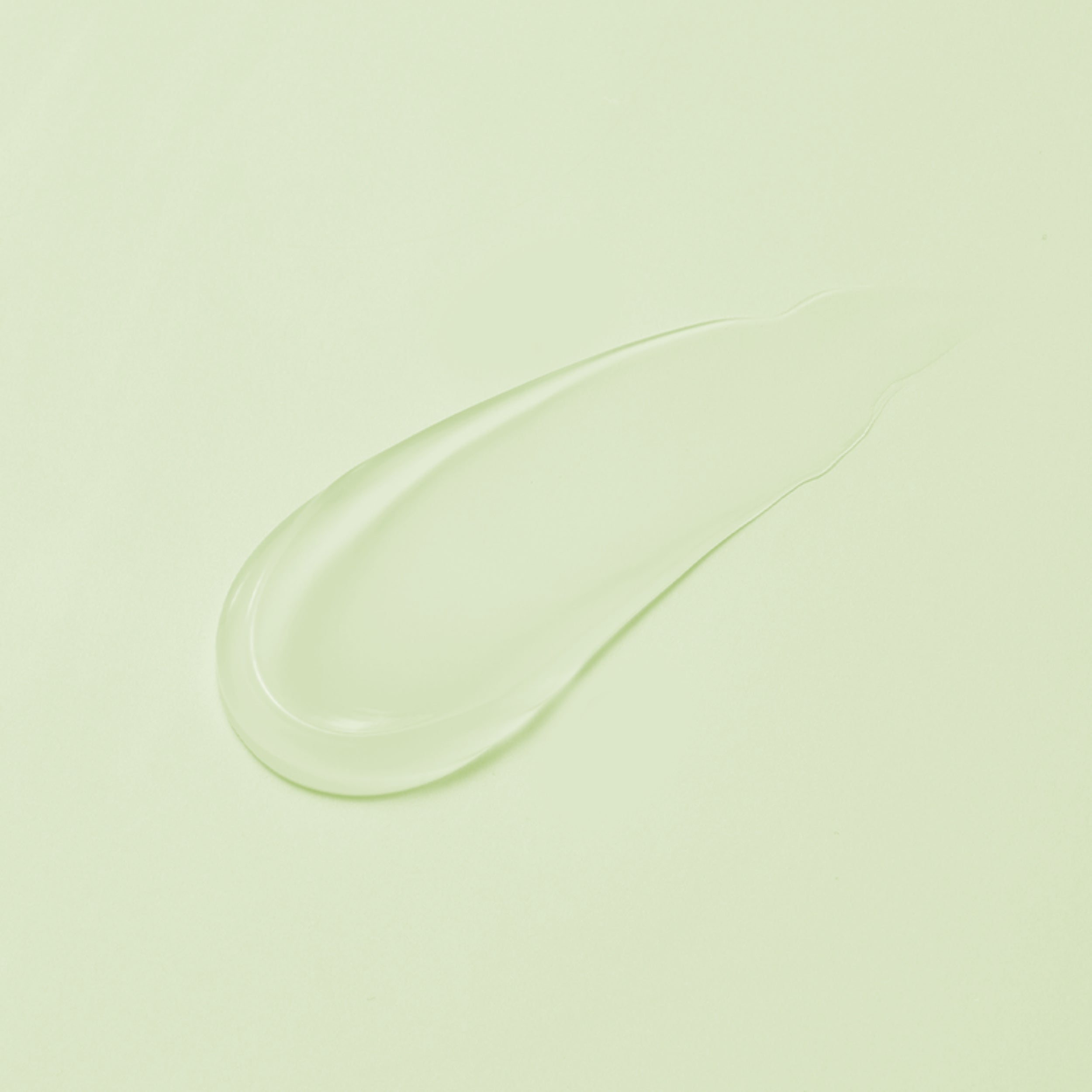 Close-up of a clear gel or cream smear on a light green background
