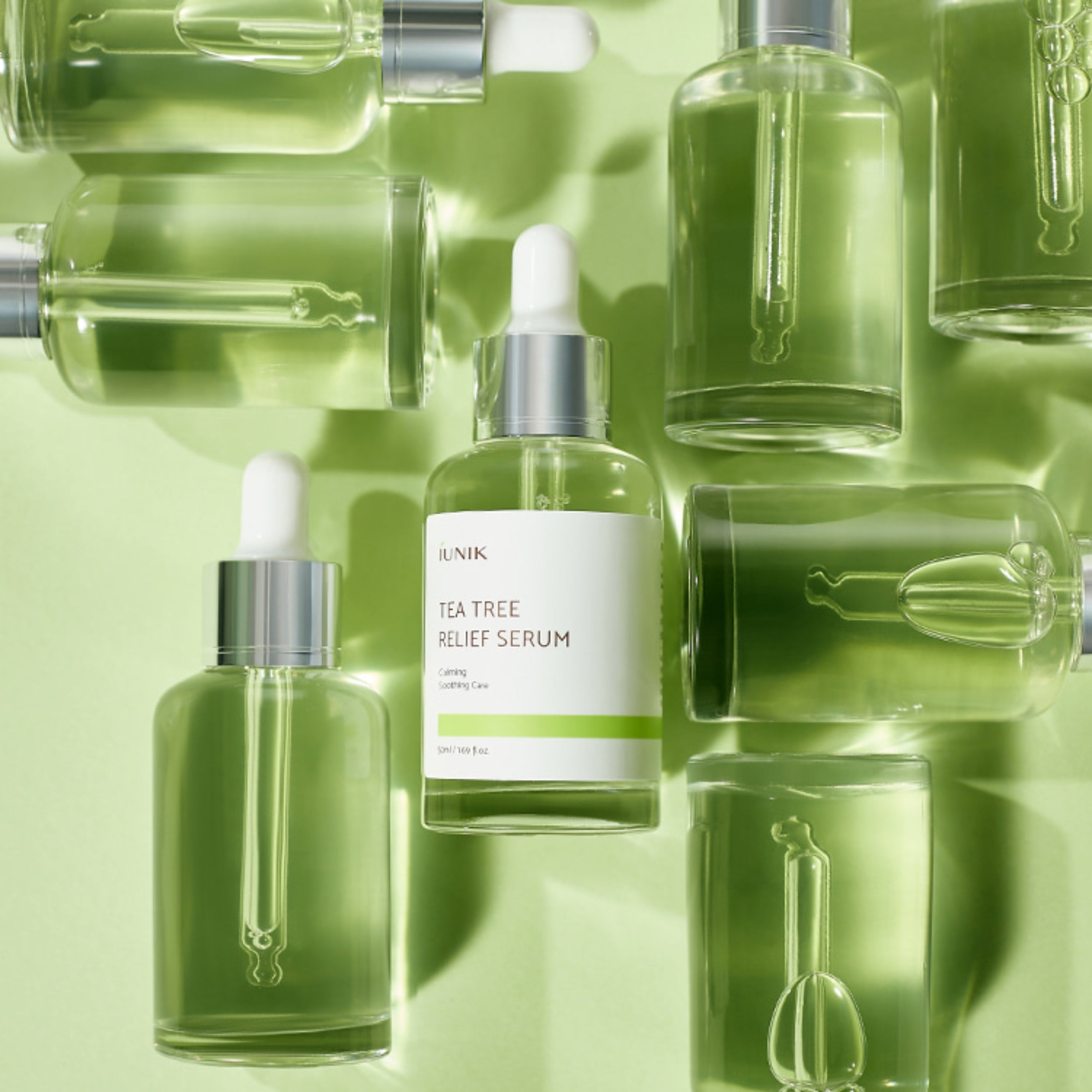 Tea tree relief serum bottle with dropper on a green background