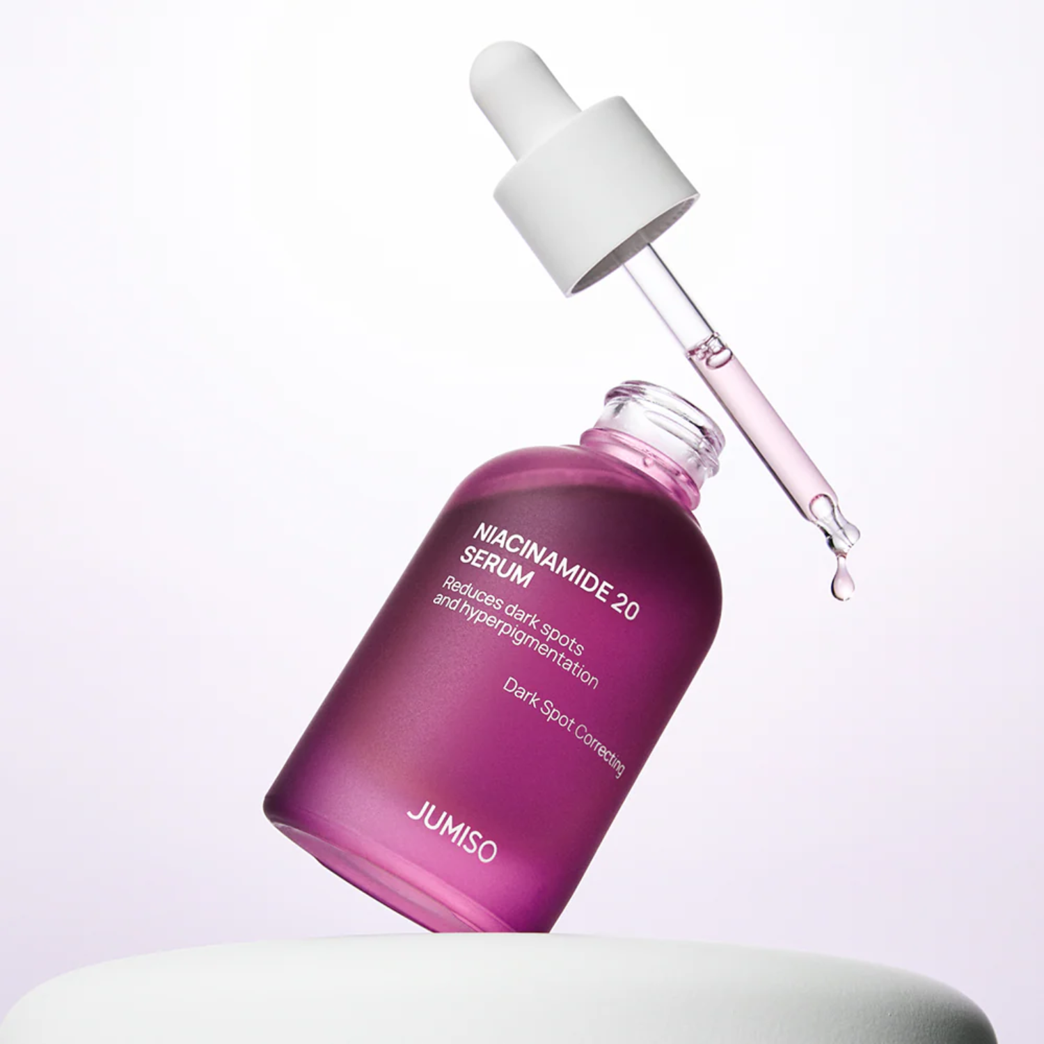 Purple skincare serum bottle with dropper on a light gray background