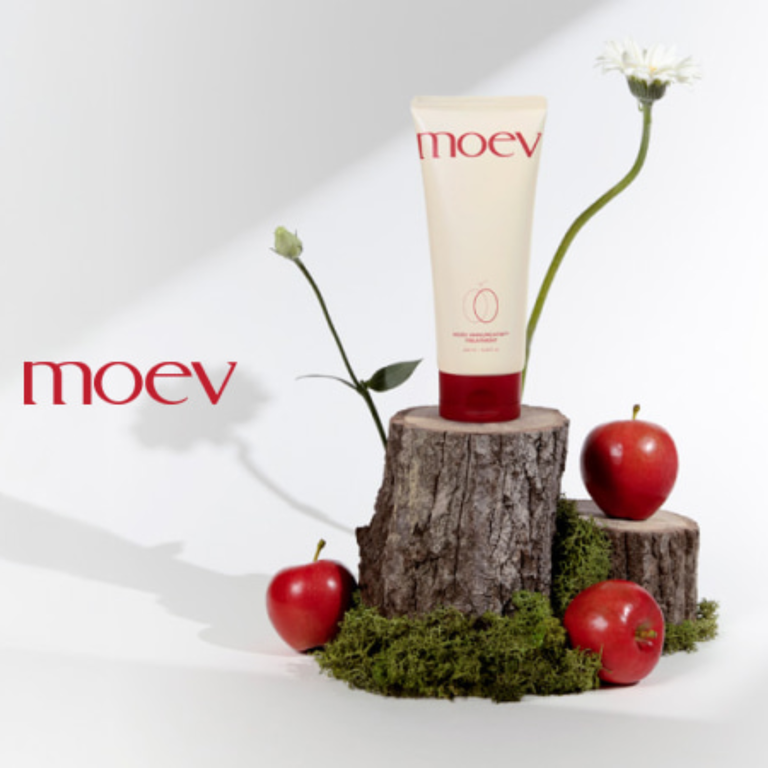 Tube of moev cream on a wooden stump with apples and flowers on a white background