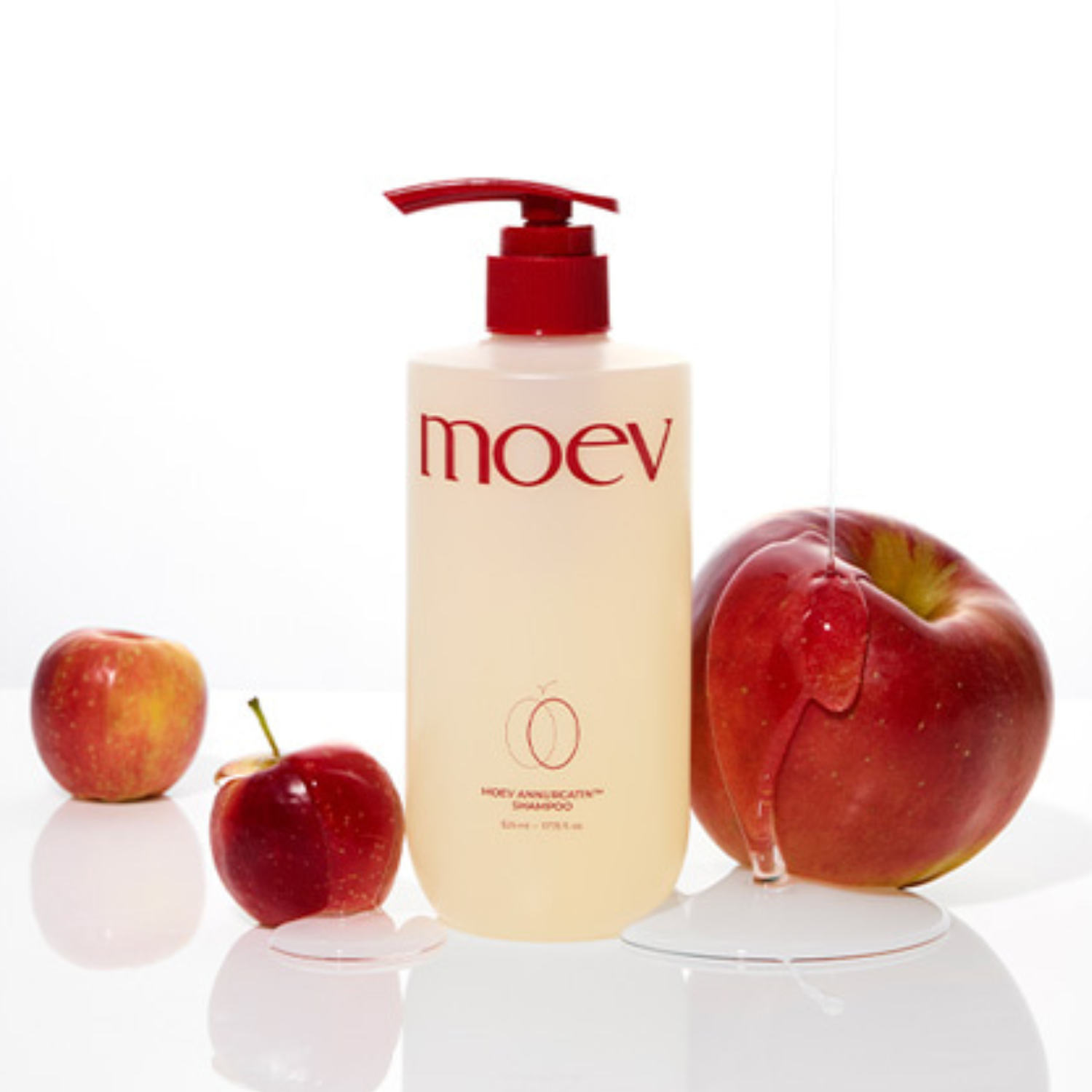 Bottle of moev product with red apples on a white background