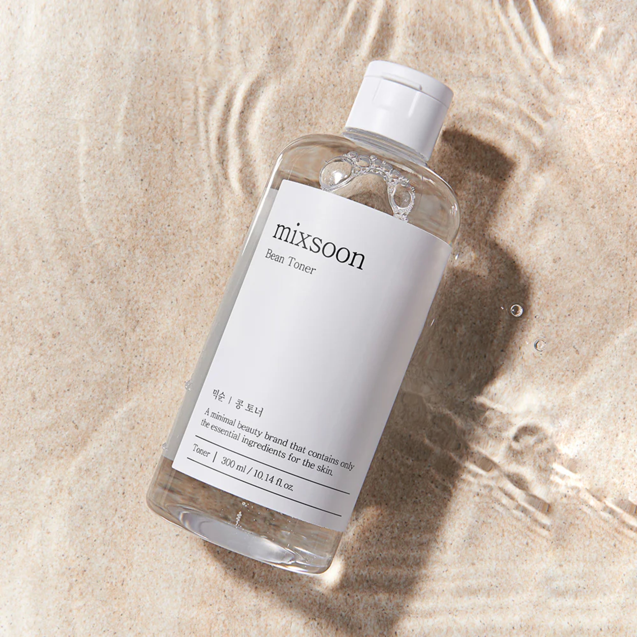 Bottle of mixsoon beauty toner on a textured beige surface