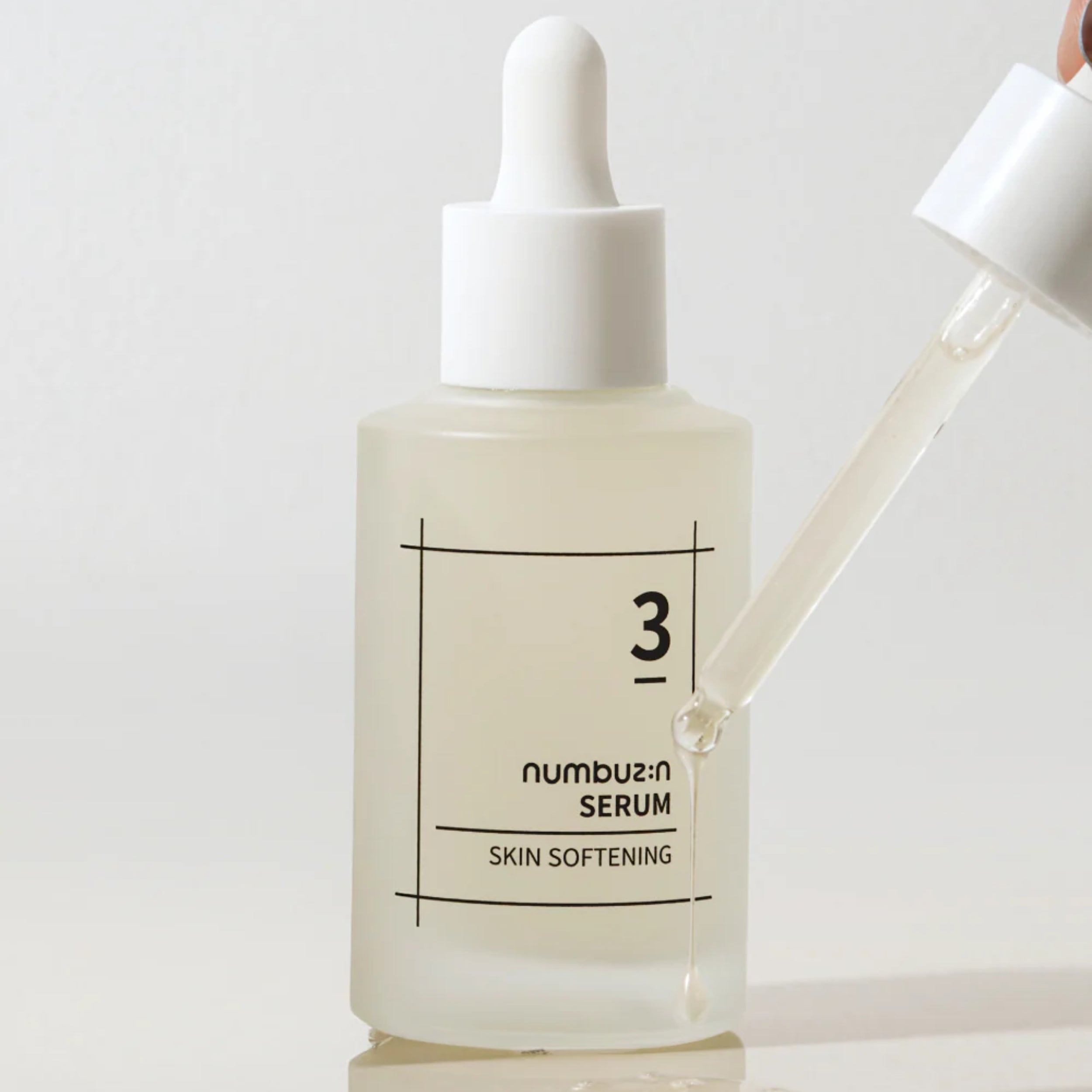 Skincare serum bottle with dropper on a light background