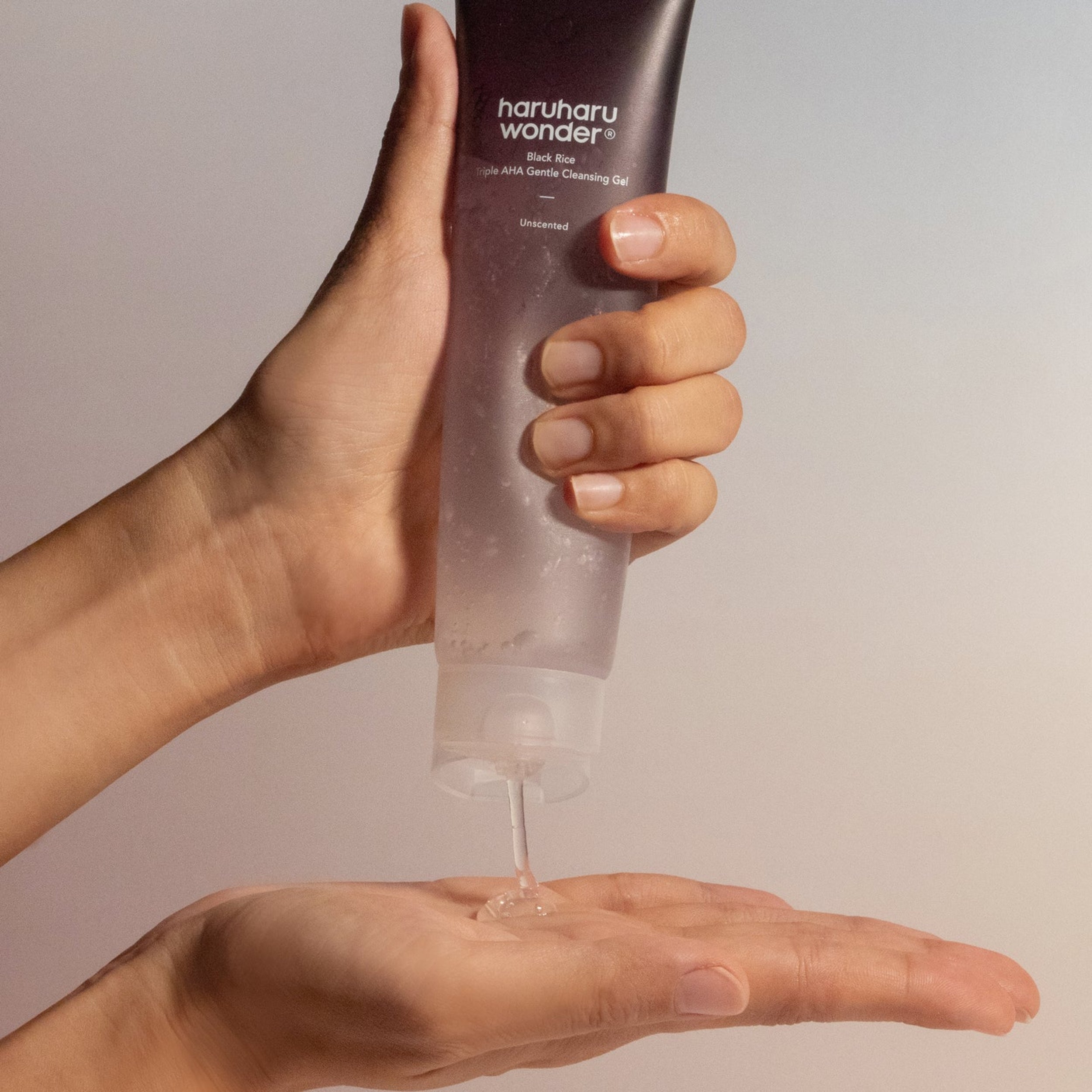 Hand holding a bottle of haruharu wonder gel with a neutral background