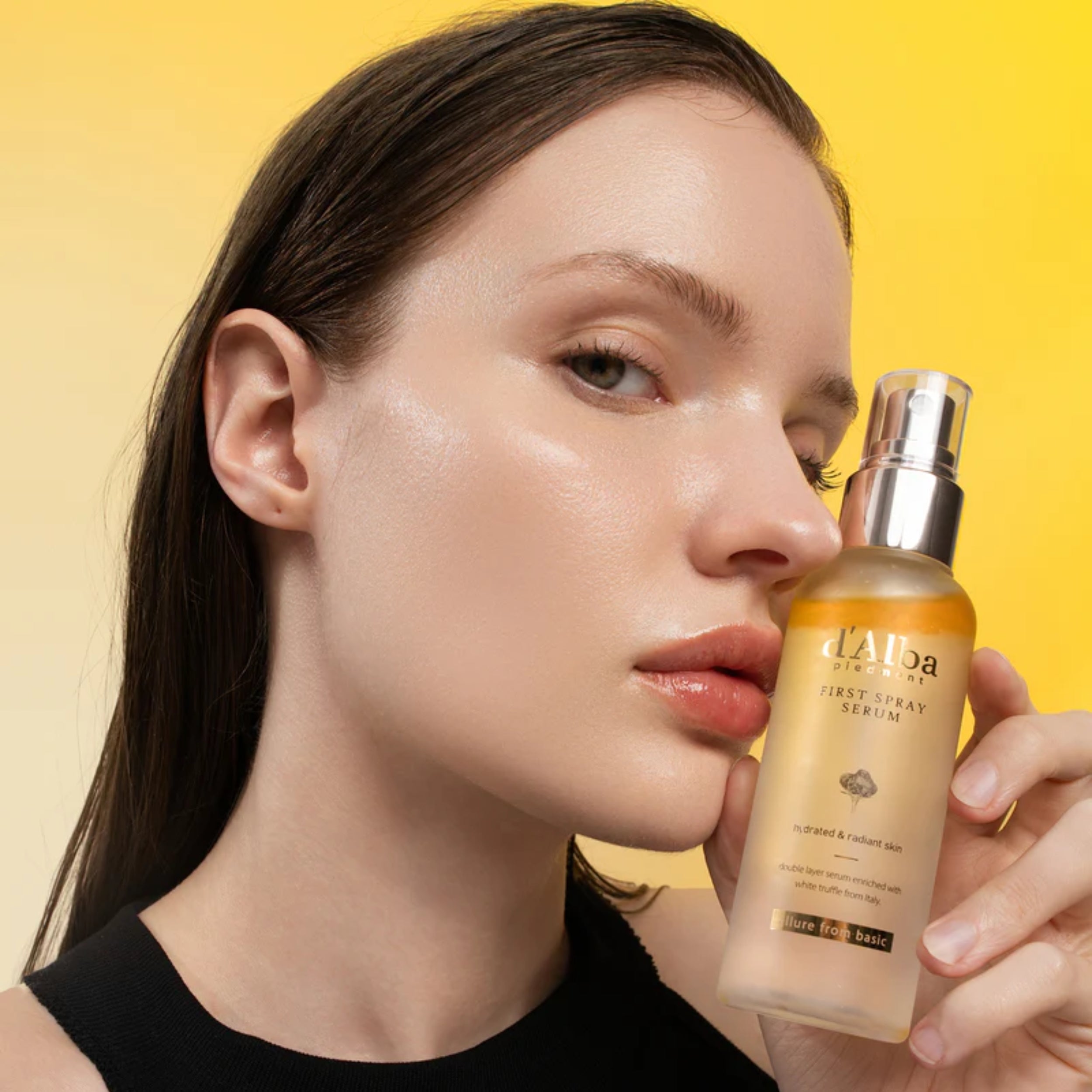 Woman holding a skincare serum bottle with a yellow background