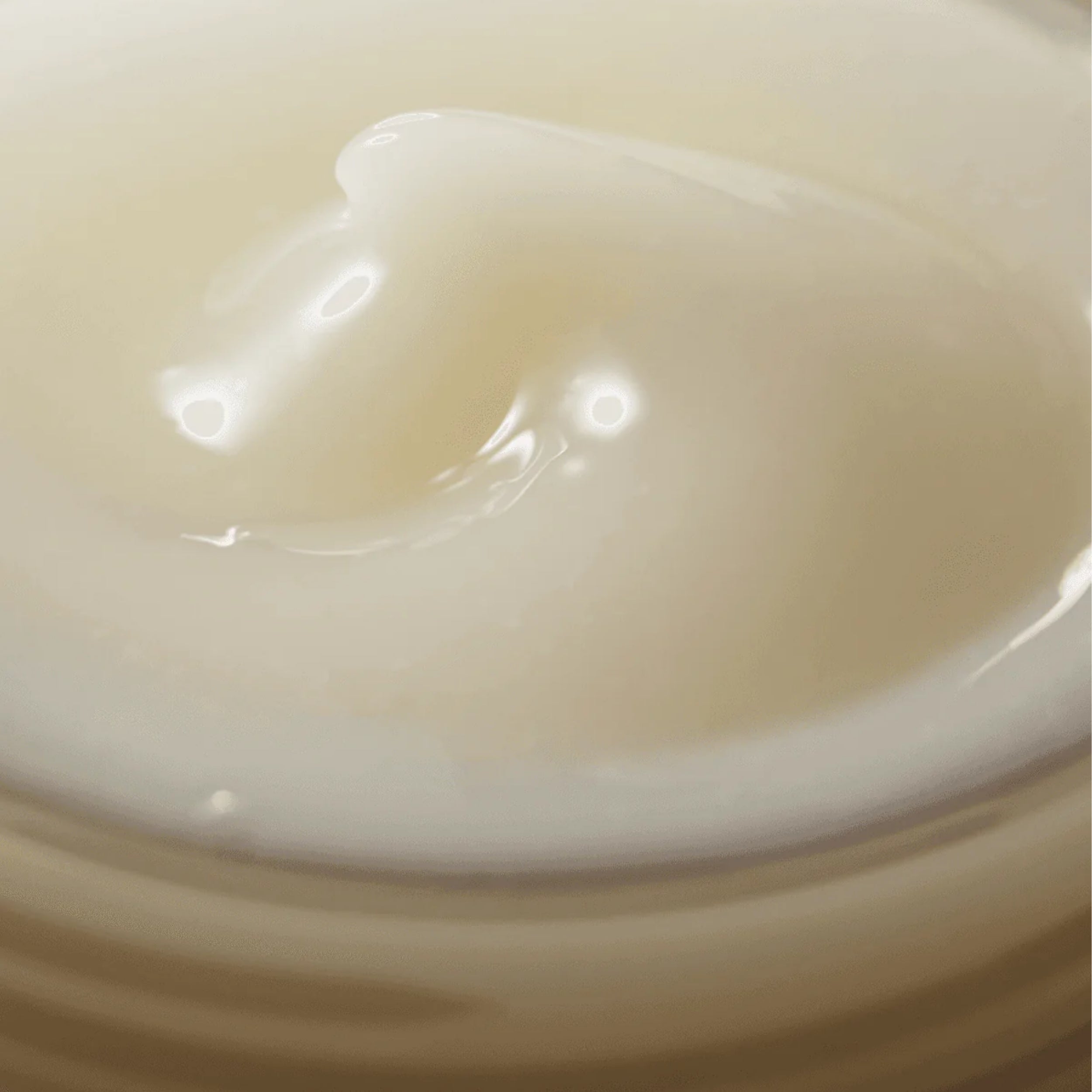 Close-up of a smooth, creamy texture on a beige background