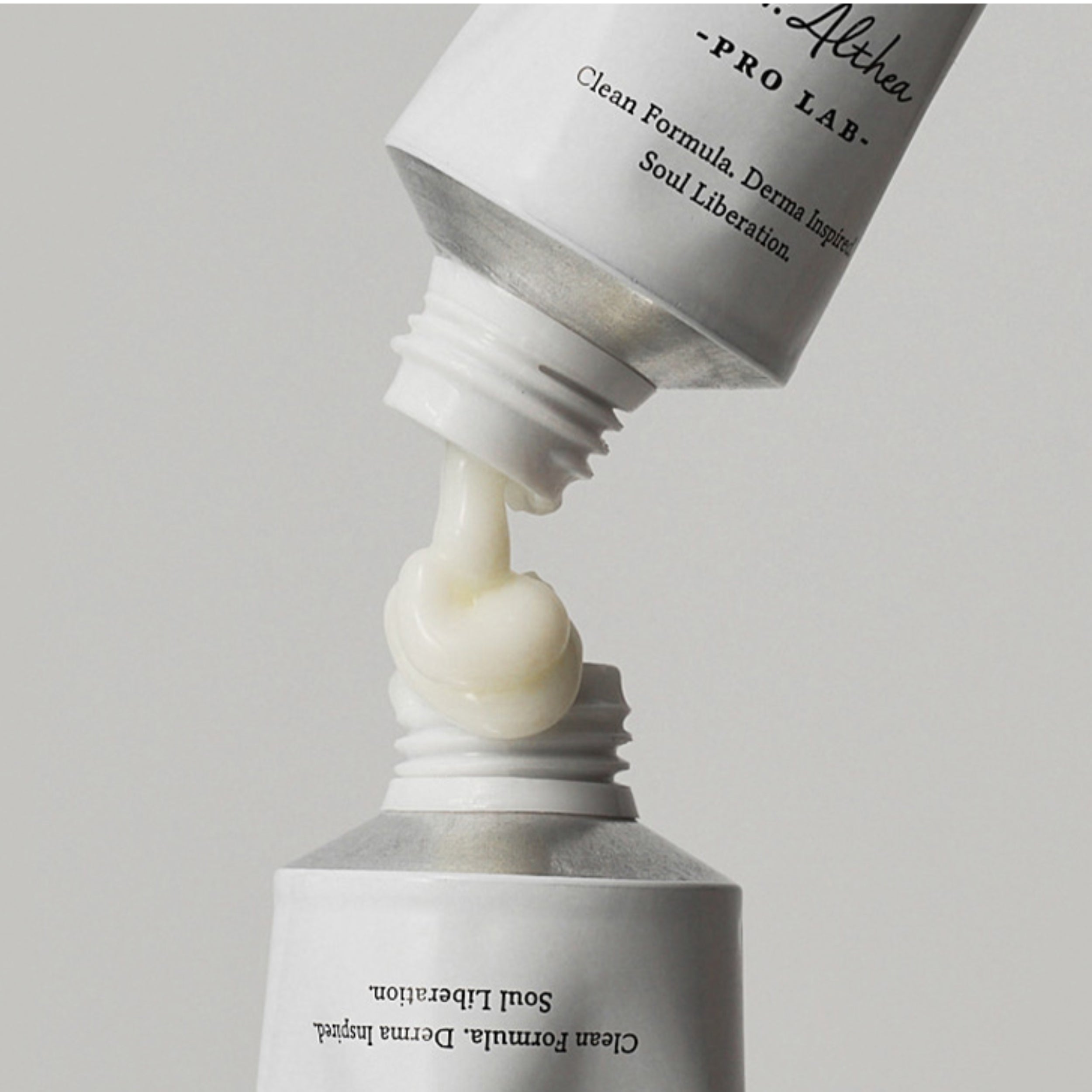 Close-up of a skincare product being dispensed from a tube labeled 'Althea Pro Lab'.