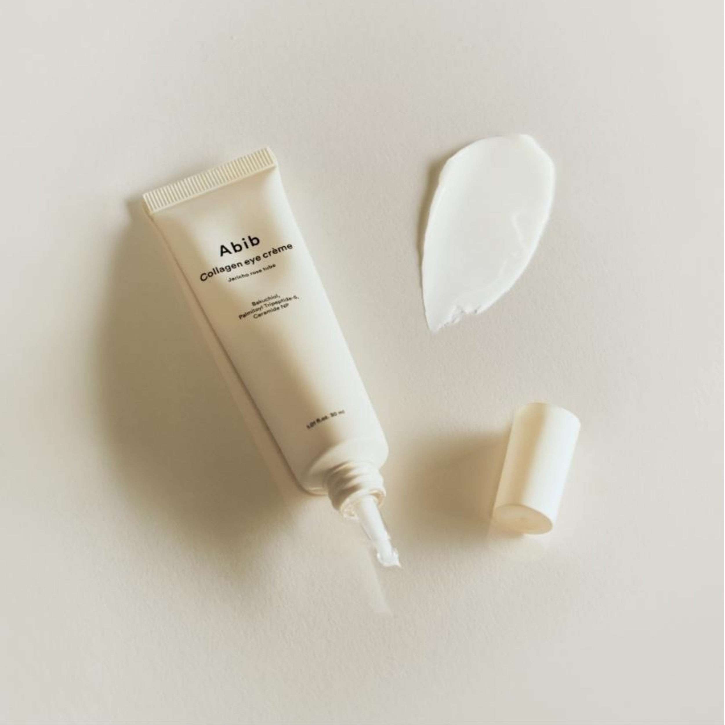 Tube of Abib Collagen eye crème with applicator on a light background