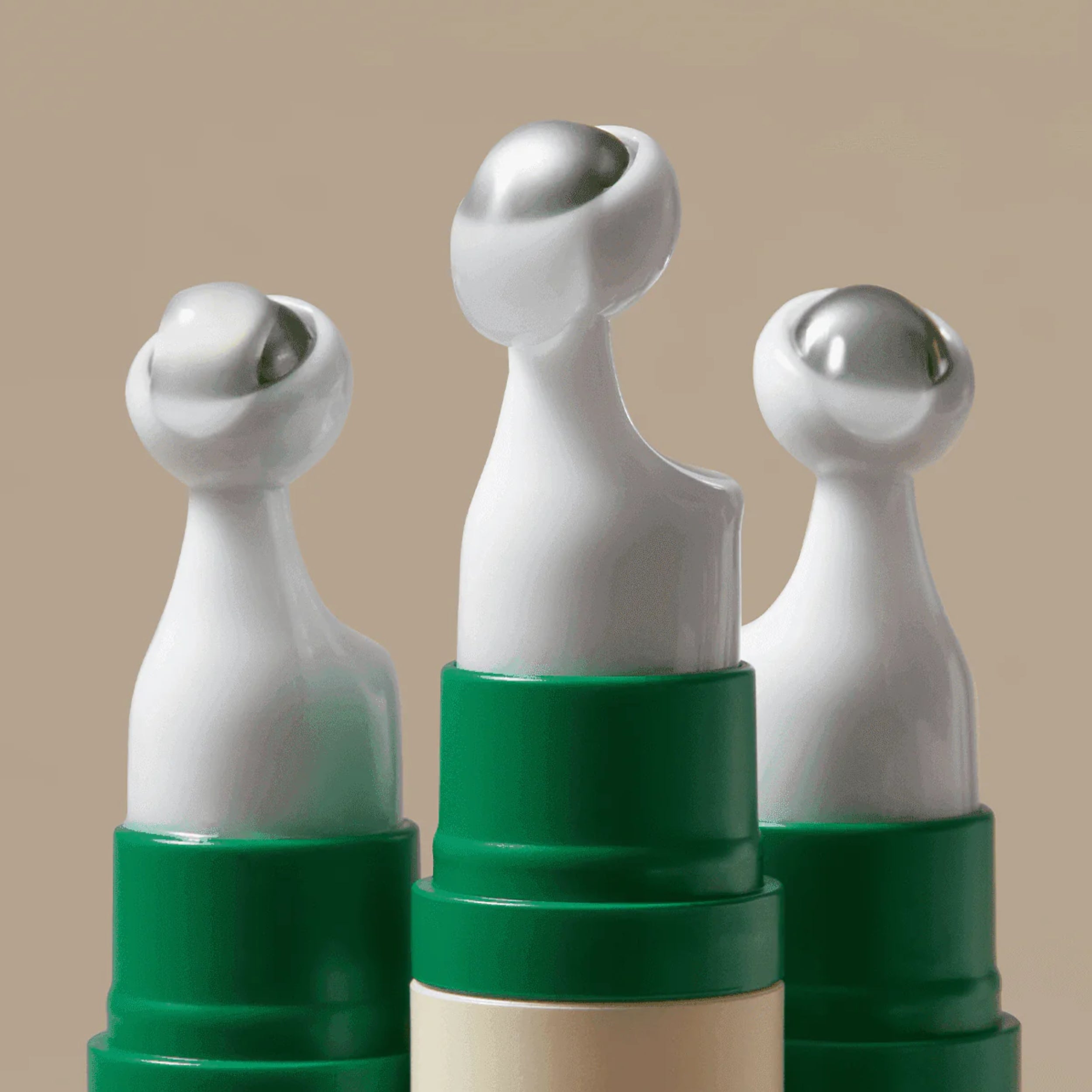 Three white and green ceramic figures on a beige background