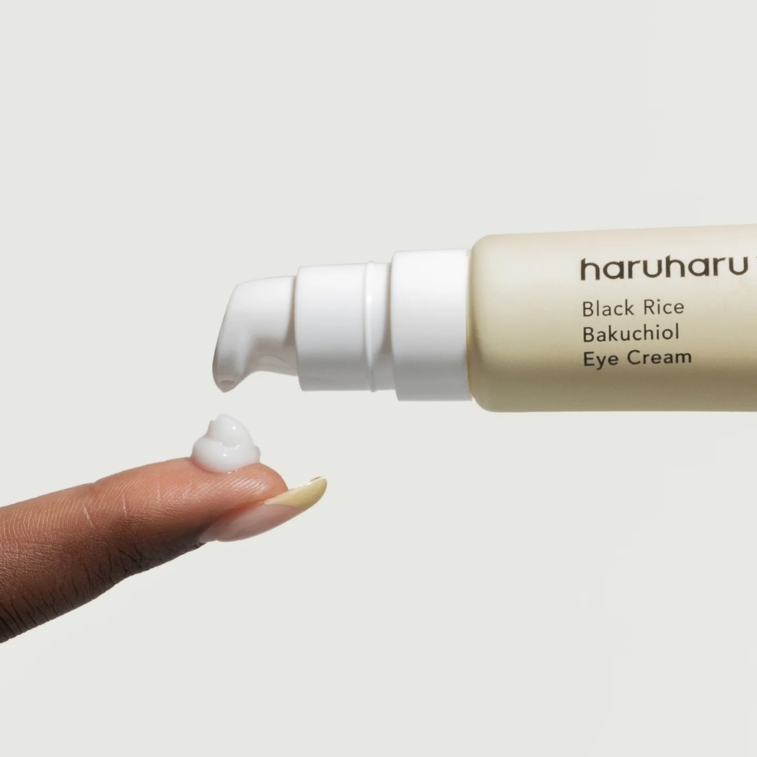 Haruharu Black Rice Bakuchiol Eye Cream being applied with a finger on a light background