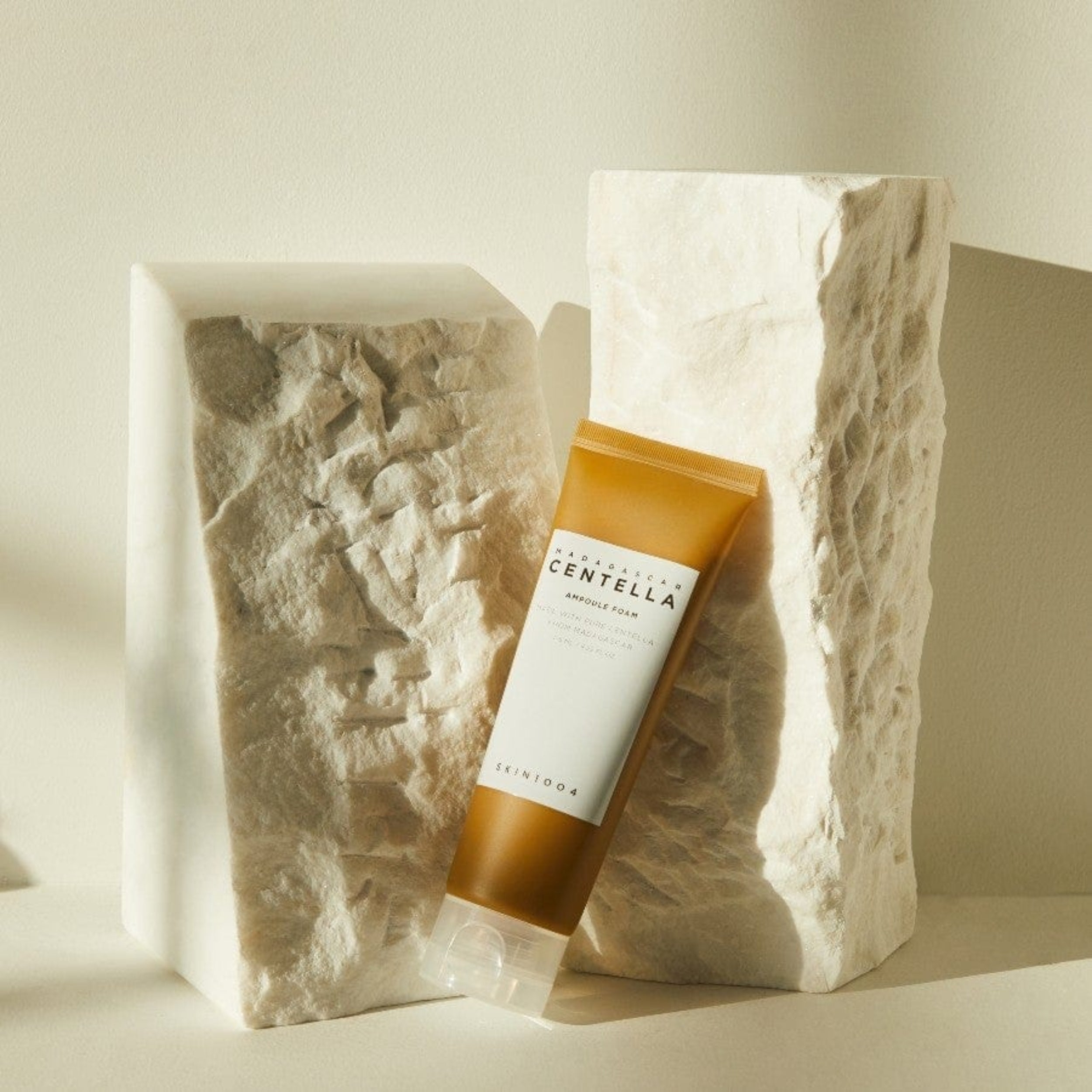 Product packaging with 'CENTELLA' branding on a textured stone surface