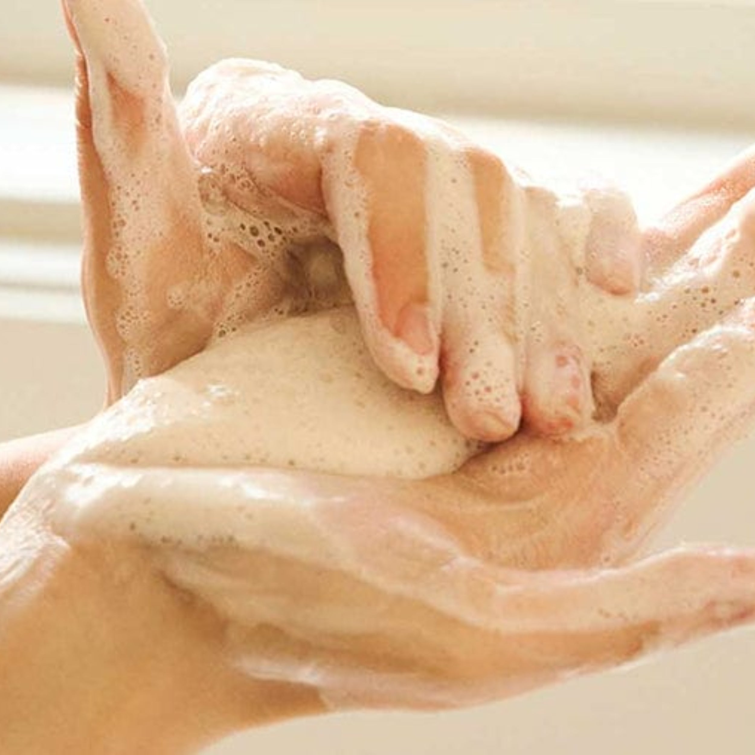Close-up of hands with soap bubbles being rubbed together