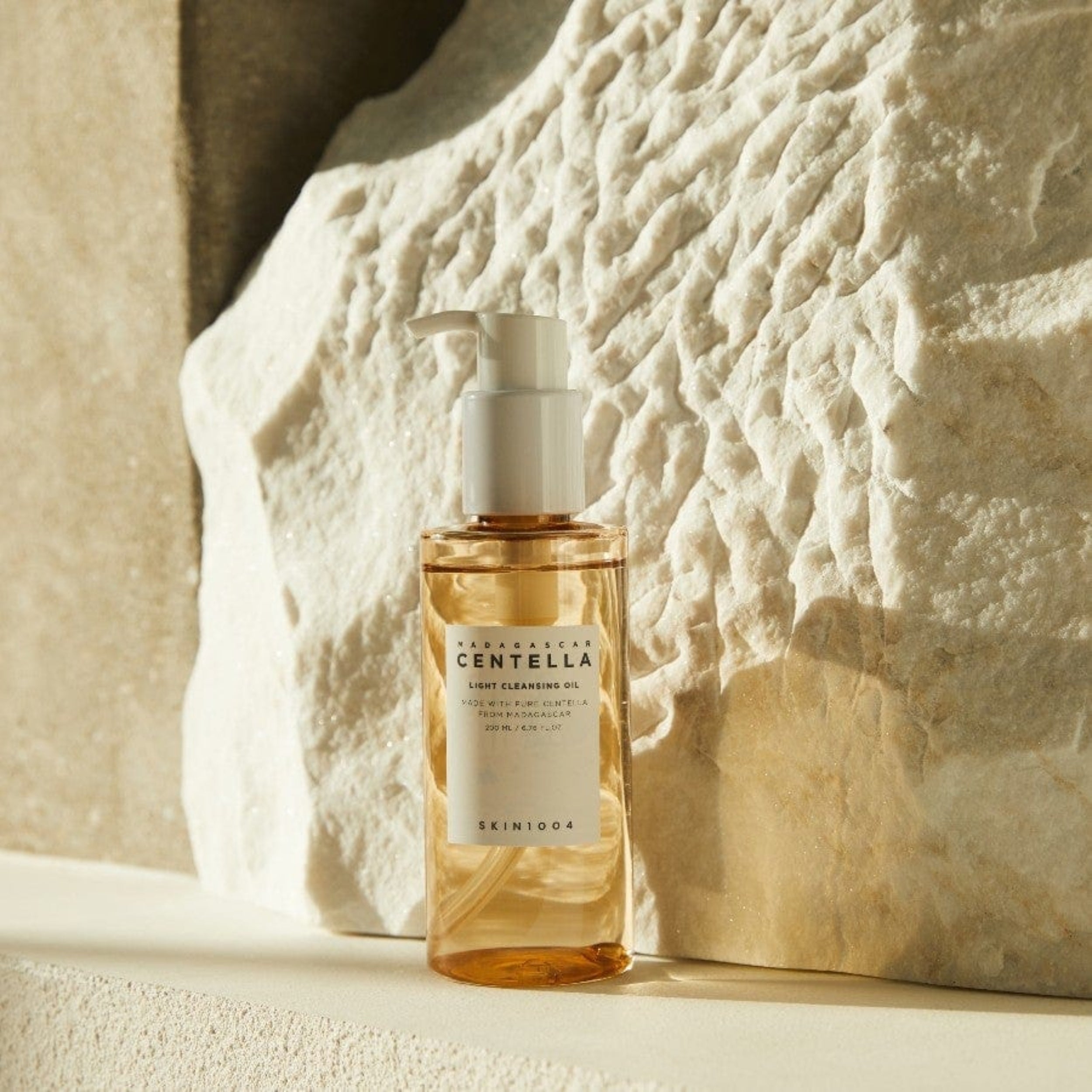 Skincare bottle labeled 'Skinceed Centella' against a textured stone wall.