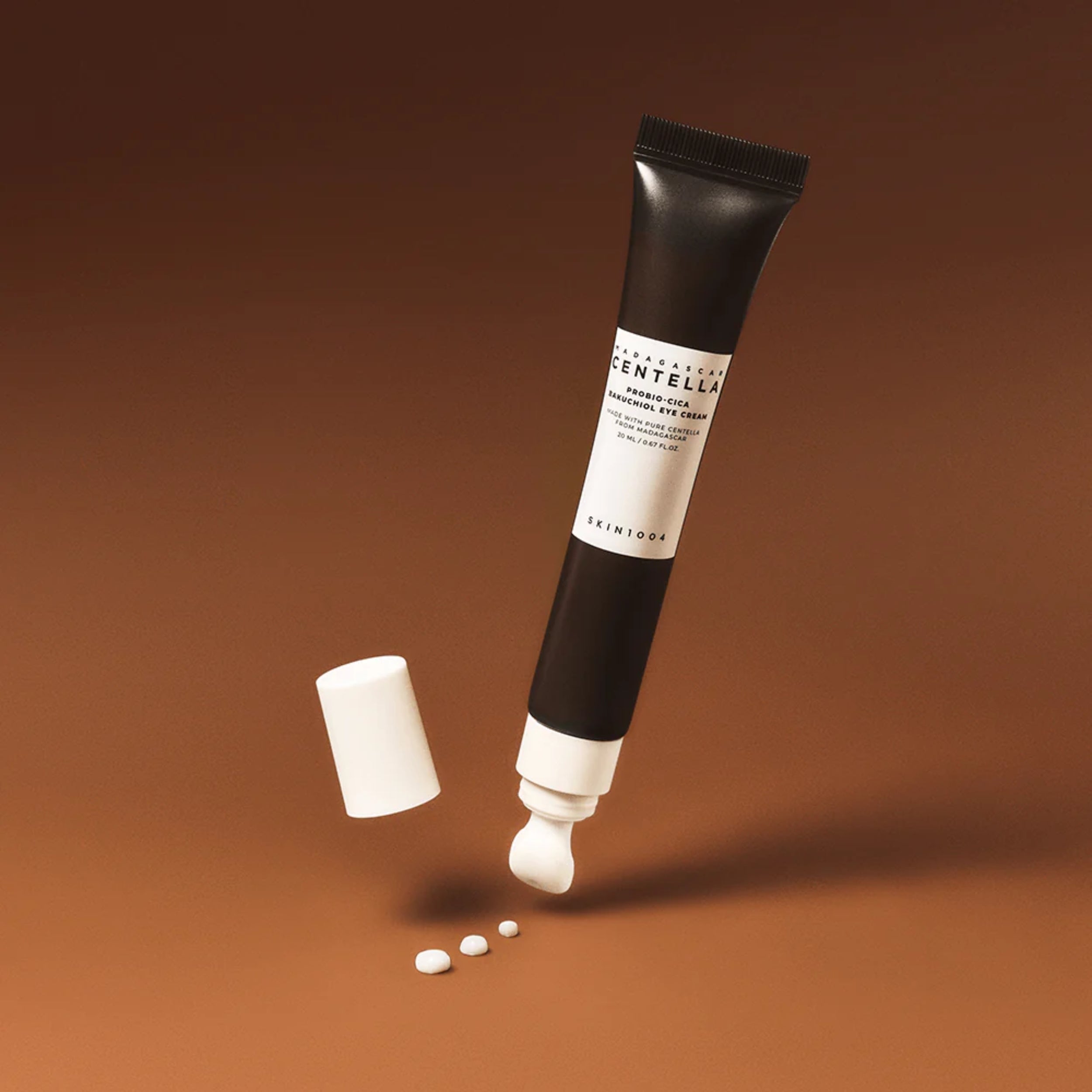 Skincare tube with cap and capsules on a brown background