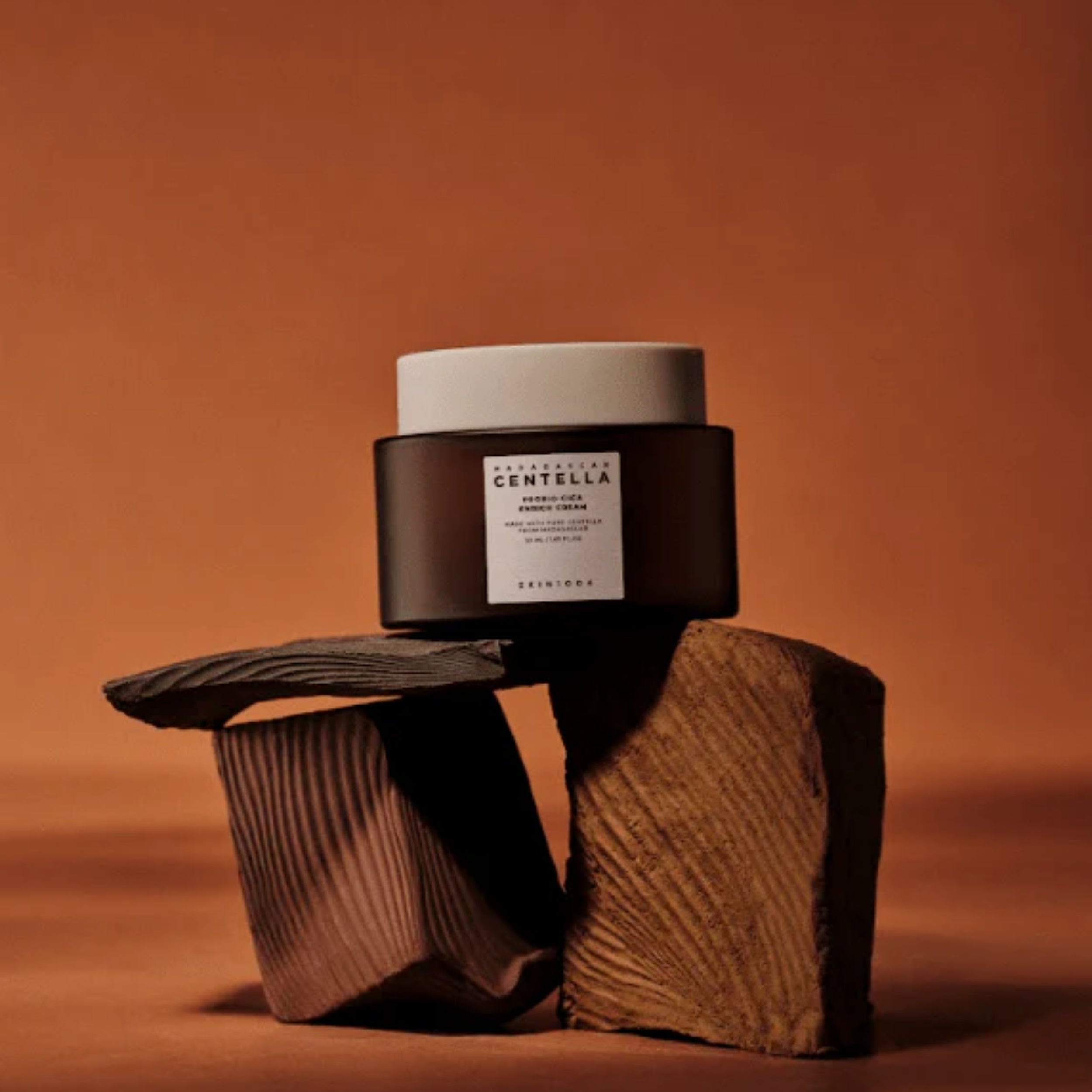 Cosmetic jar with a label on a textured brown surface