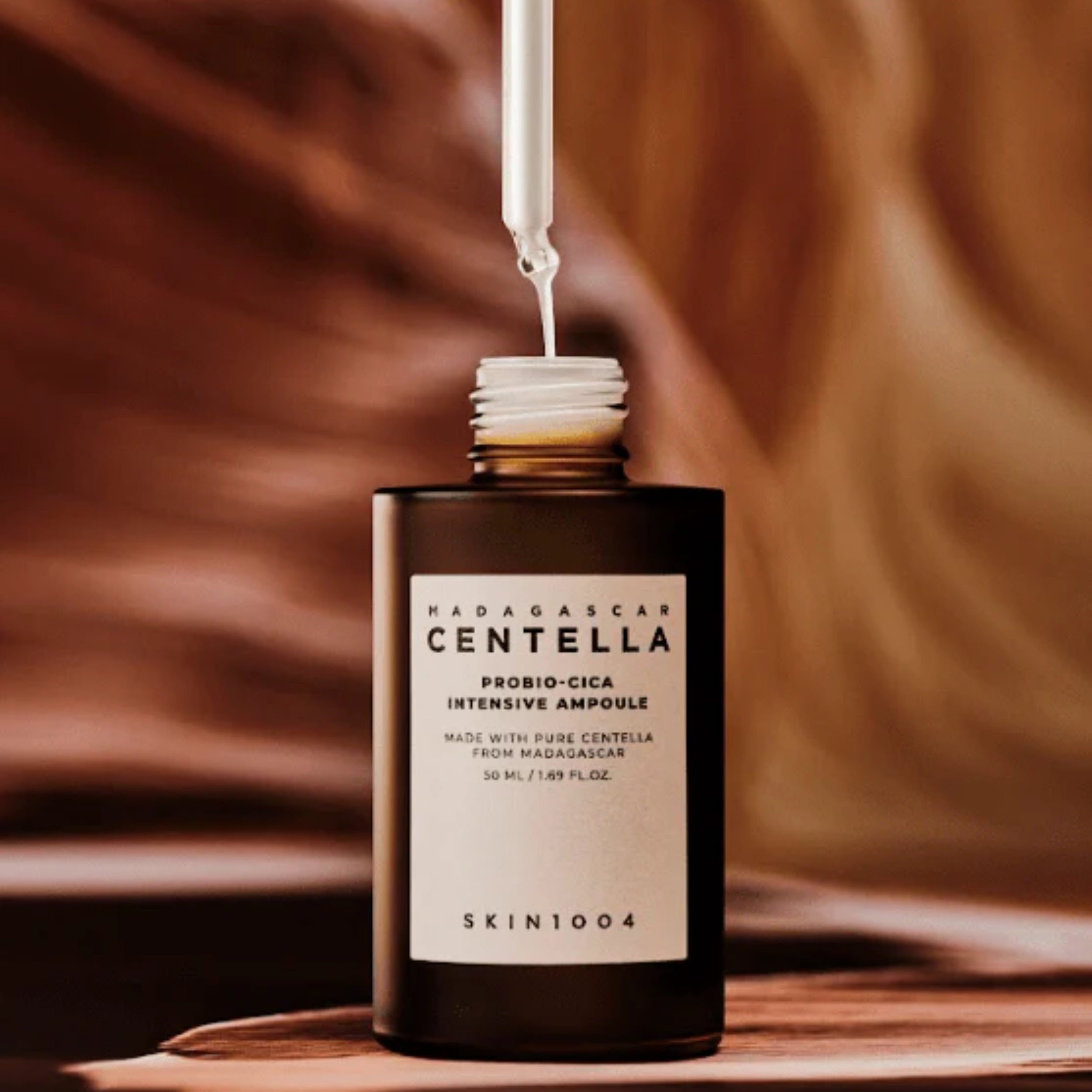 SKIN1004 Madagascar Centella Probiotic-Cica Intensive Ampoule bottle on a brown background