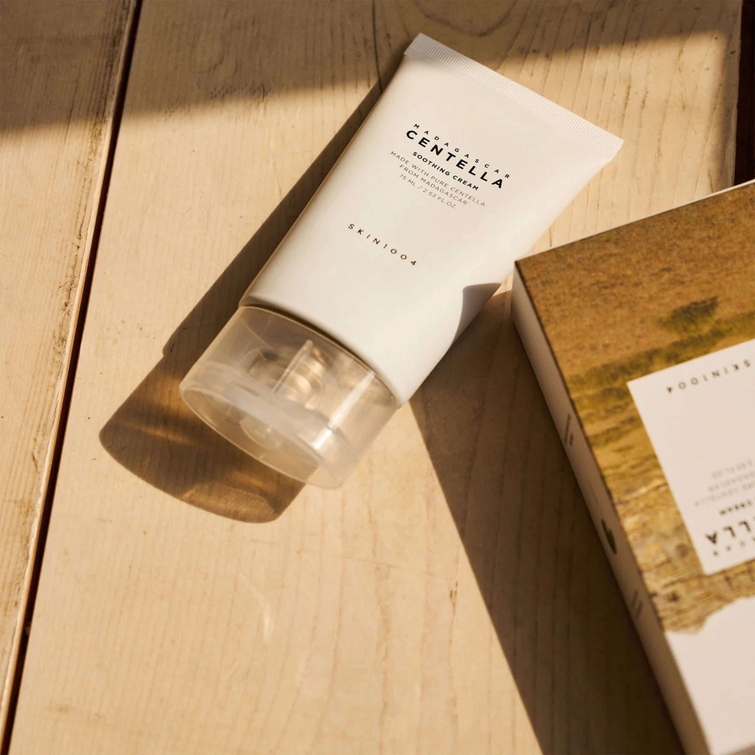 Skincare product with Centella Asiatica on a wooden surface