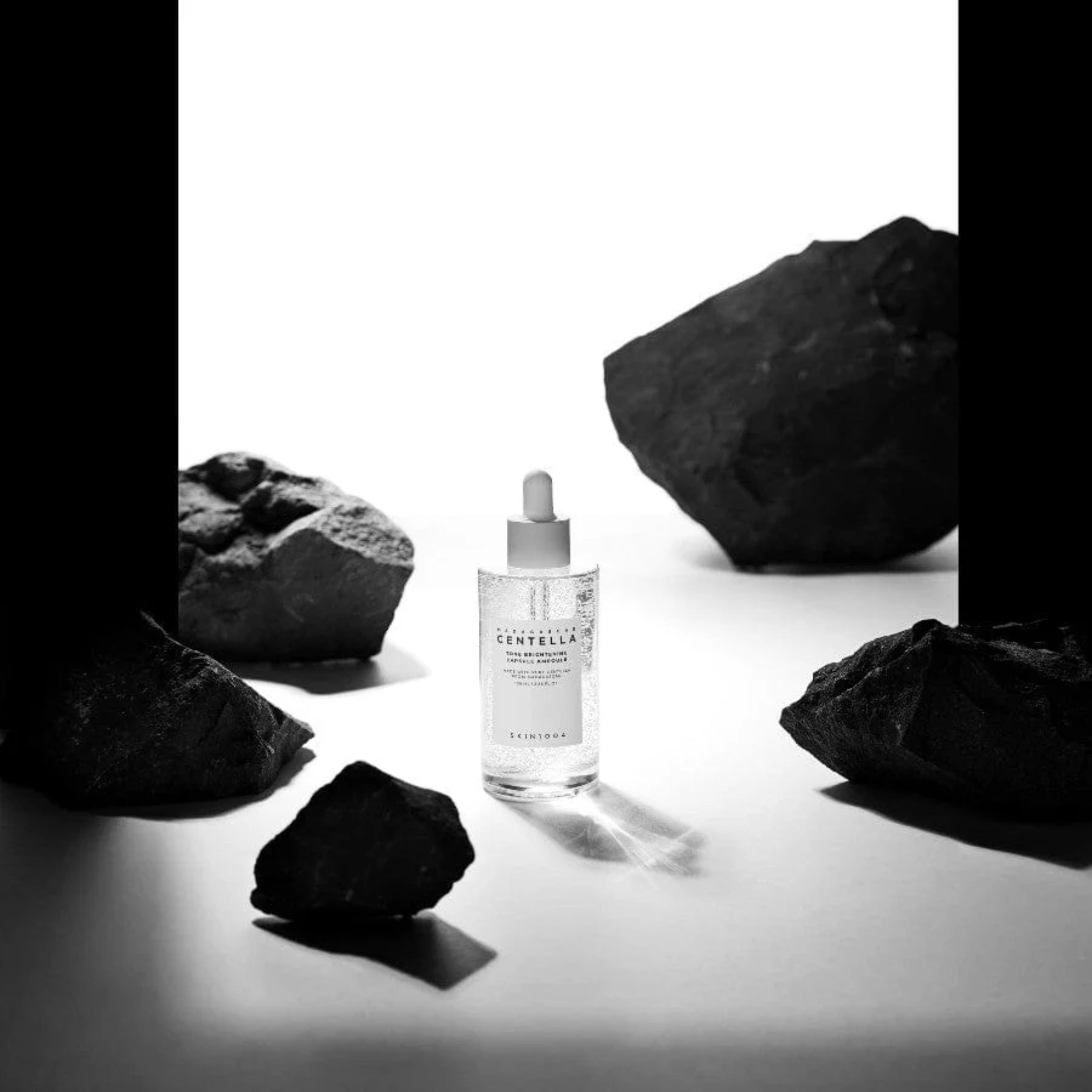 Skincare bottle with rocks on a white background