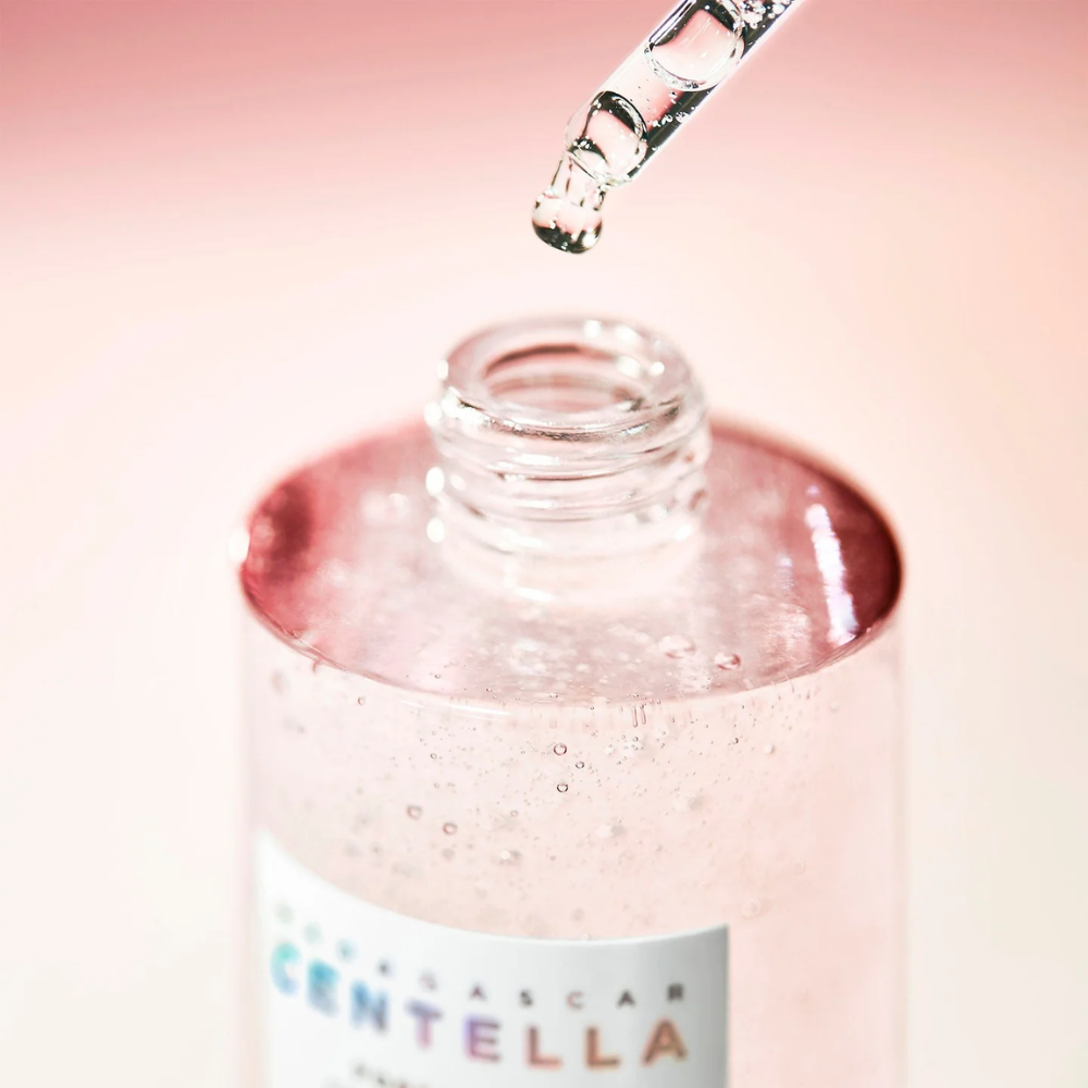 Bottle of Centella with dropper on a pink background