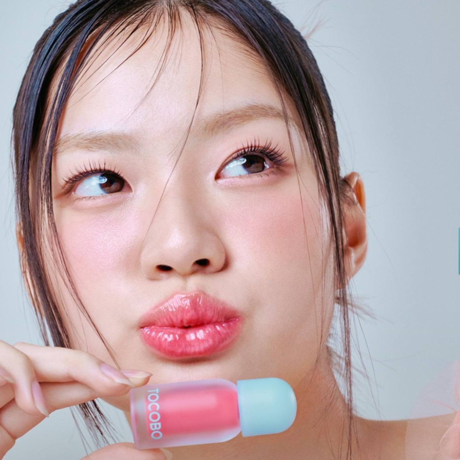 Person holding a TOCOBO lip balm with a neutral background