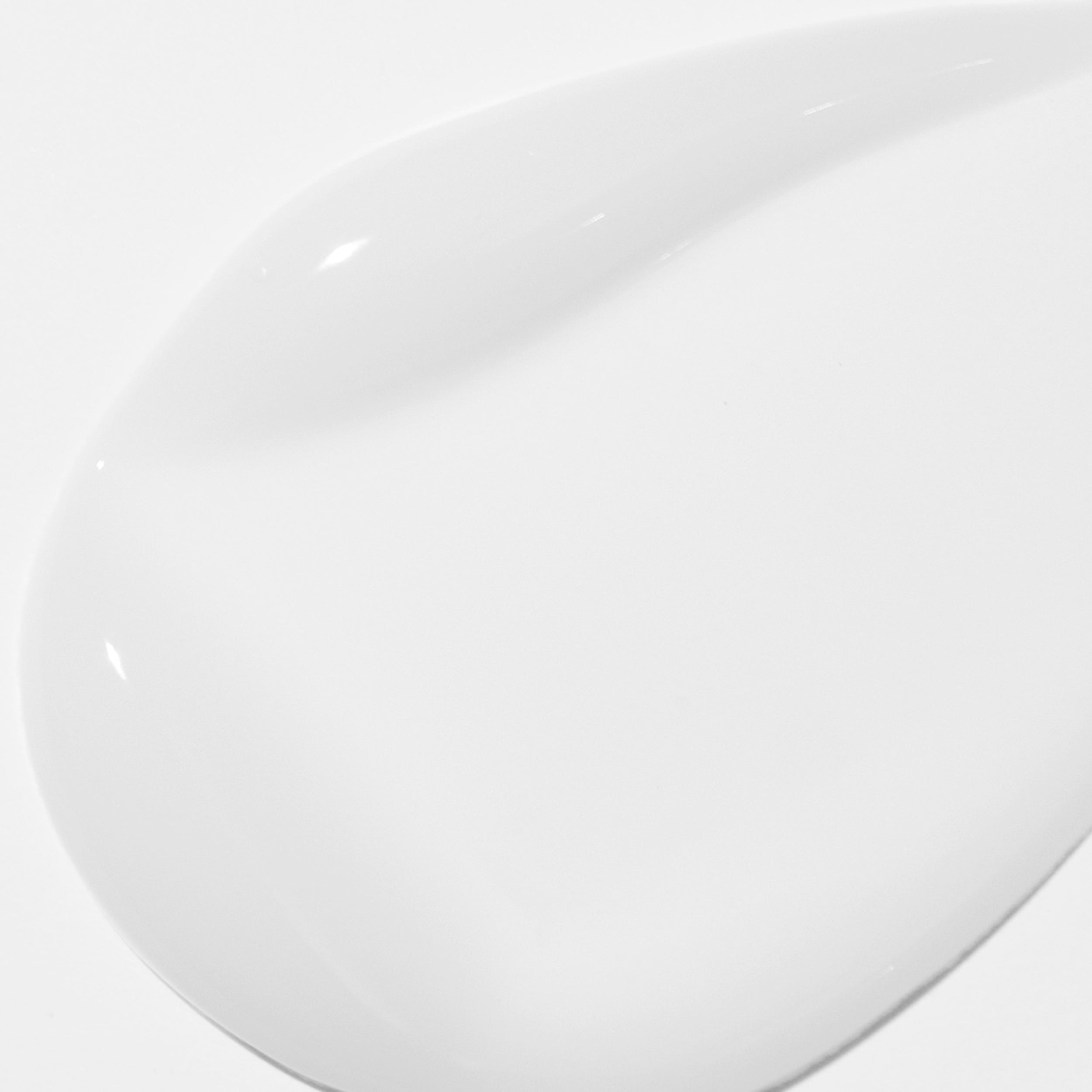 Close-up of a white ceramic plate with a glossy finish on a white background