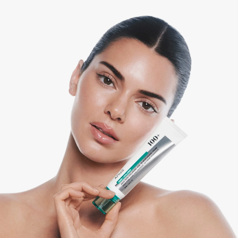 Woman holding a skincare product with a white background