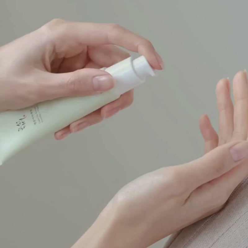 Lightweight serum in a green tube applying on the skin.